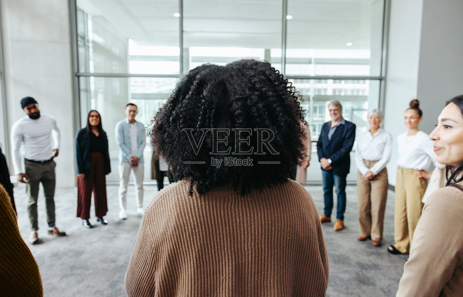 女商人在会议上发言，同事们围成一圈站立照片摄影图片