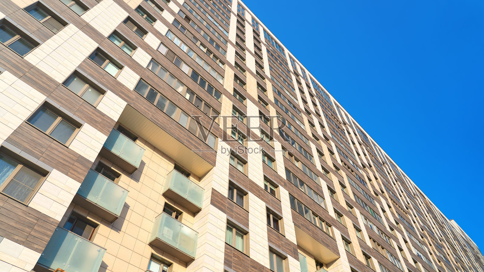 一栋高楼，拥有许多窗户和一个阳台照片摄影图片