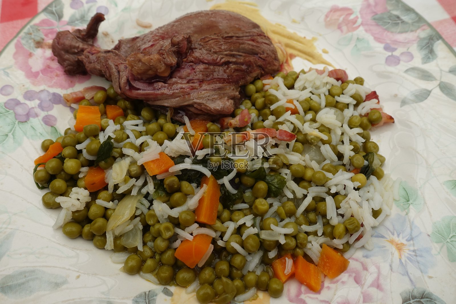 煎至金黄色的西冷牛排配香米、豌豆和胡萝卜照片摄影图片