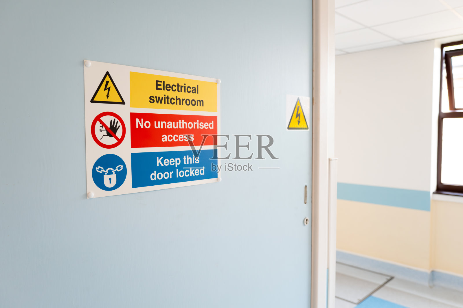 在NHS医院的X光设备入口门上看到的电气警告标志。照片摄影图片