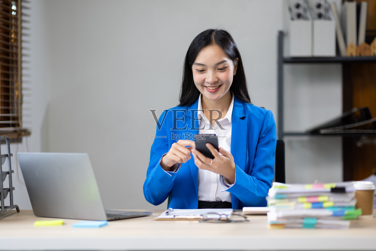 女商人使用手机在线发送信息。照片摄影图片