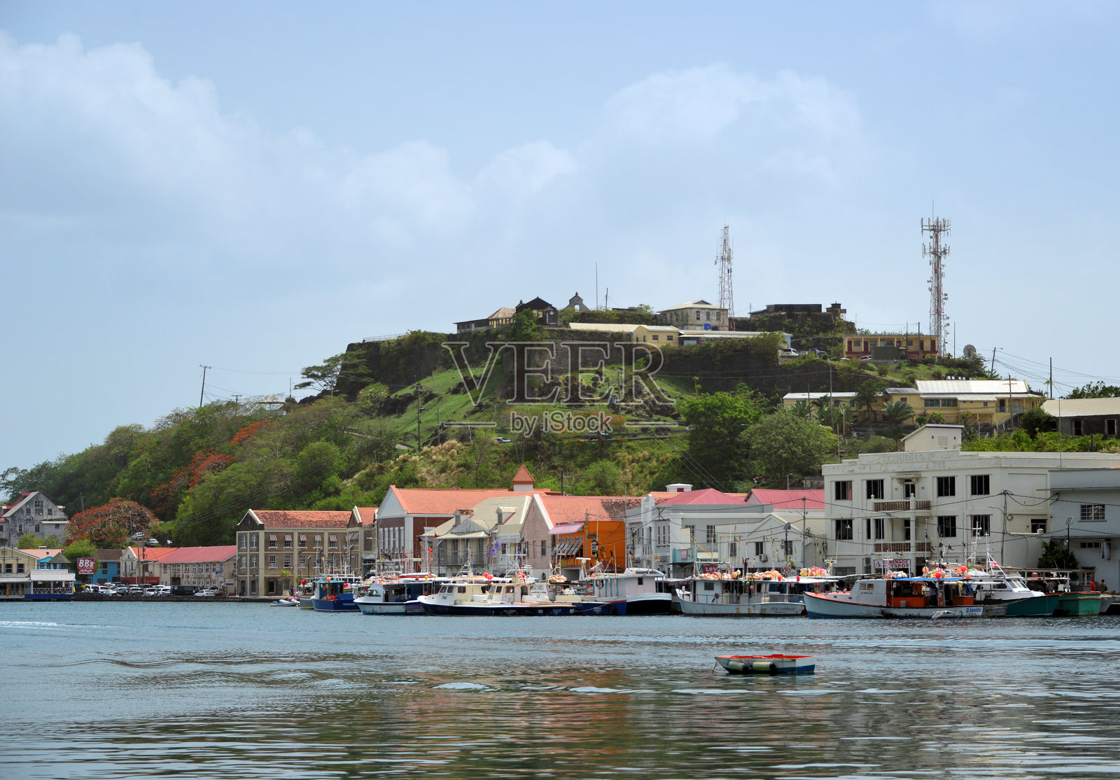 格林纳达圣乔治的山顶上的乔治堡和码头旁的渔船照片摄影图片