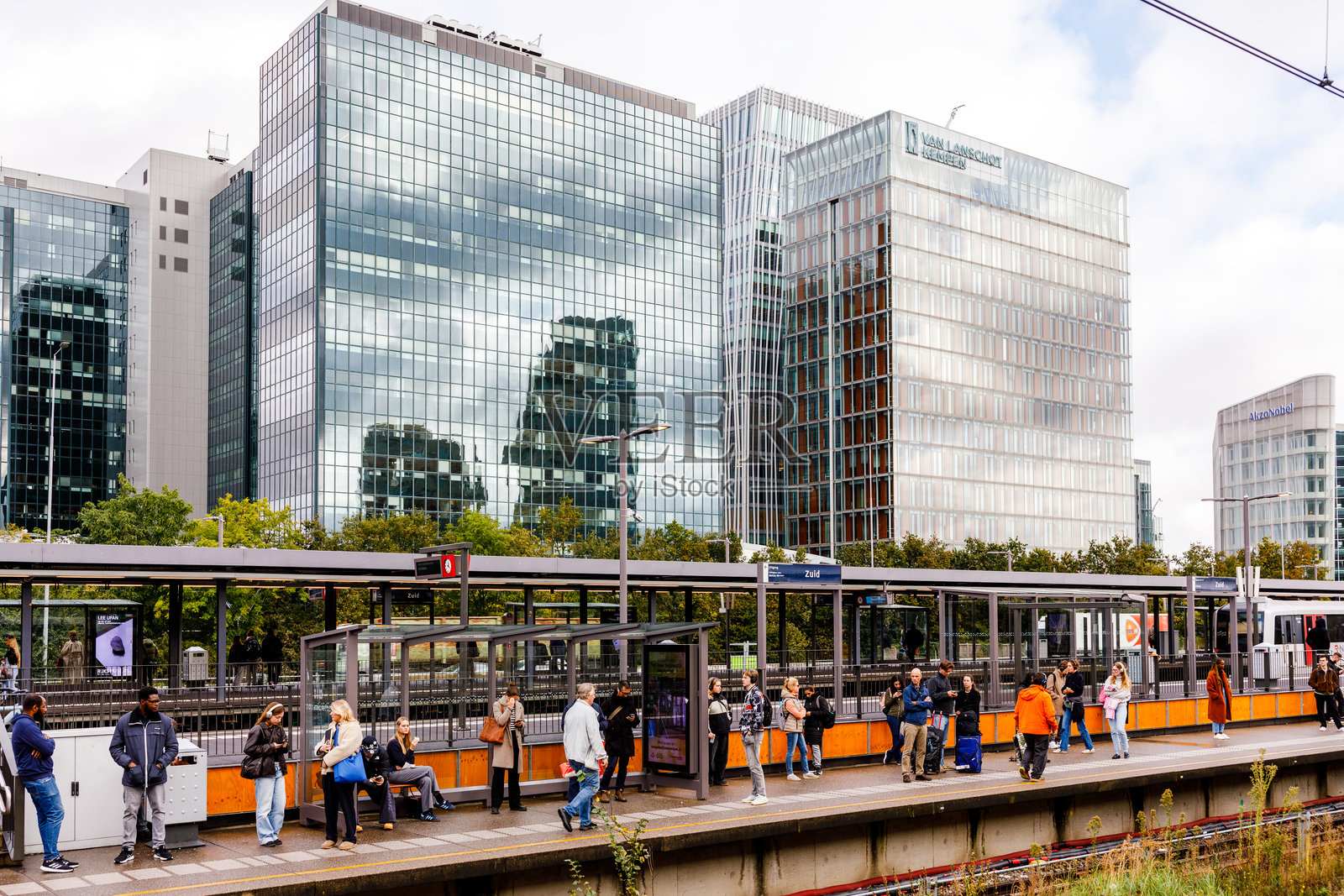 阿姆斯特丹南站地铁站候车的乘客和现代玻璃办公楼照片摄影图片