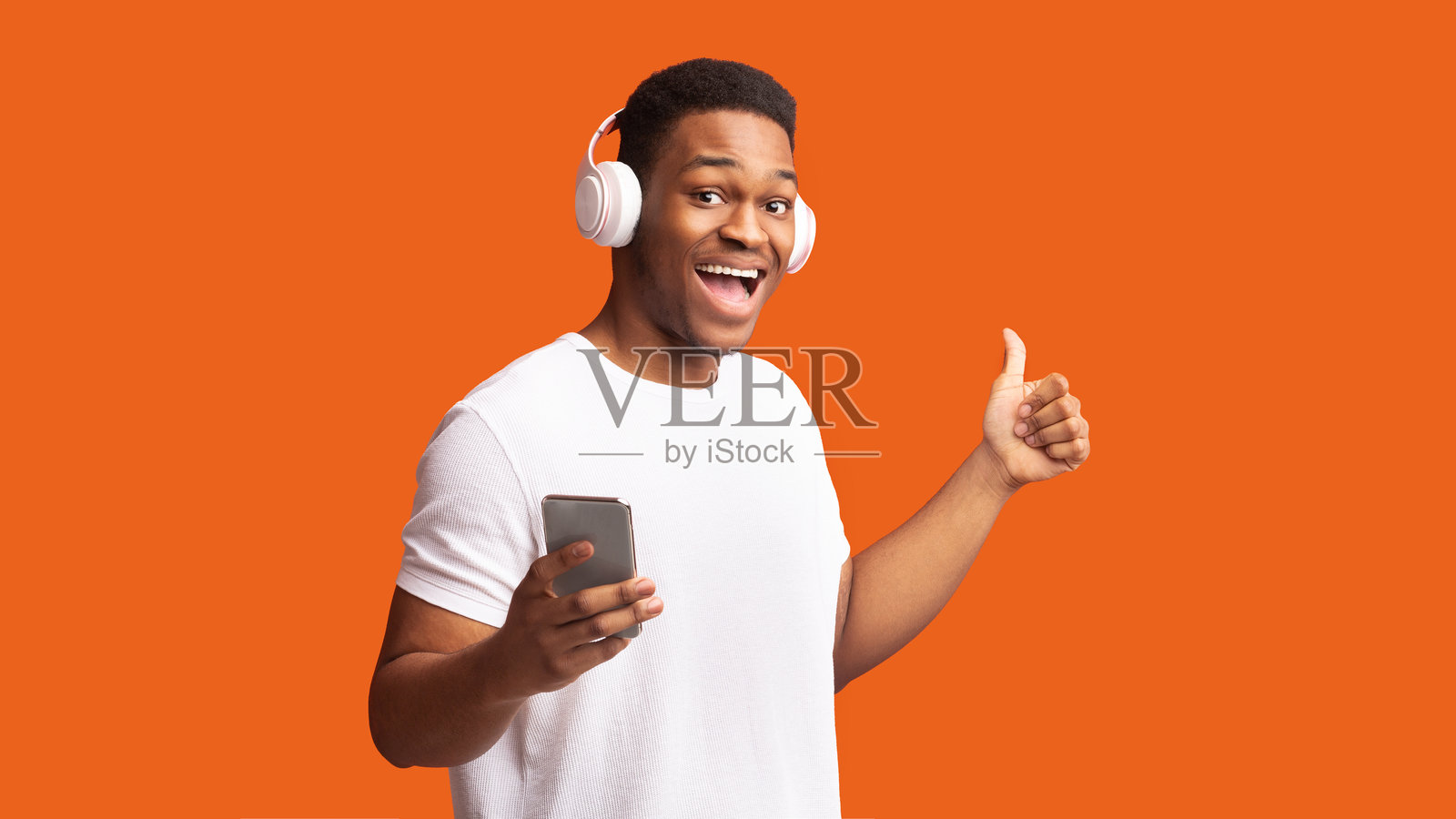 微笑的非洲裔男子戴着耳机享受音乐照片摄影图片