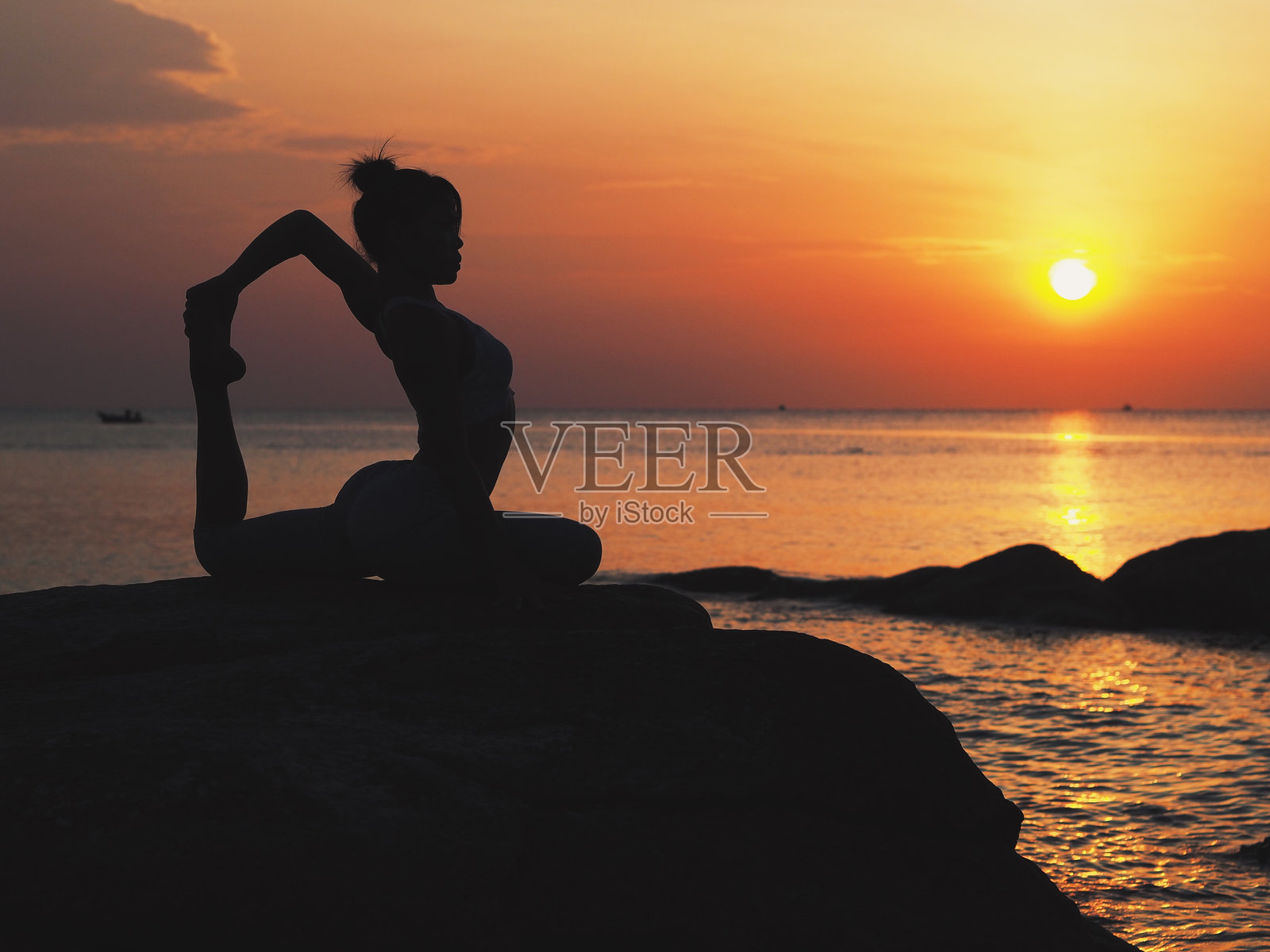 日落时分在海滩上练习瑜伽的女性照片摄影图片