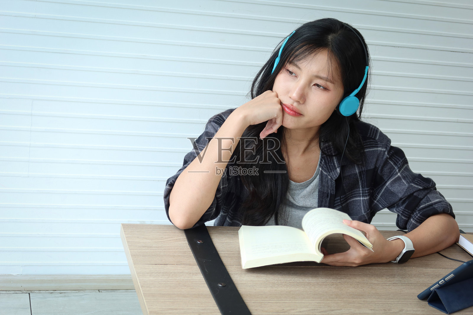 戴着耳机看书做作业的亚洲高中女生照片摄影图片