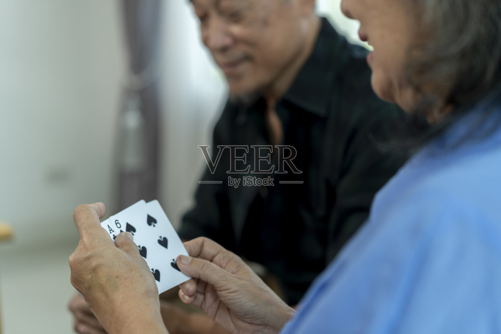 一群亚洲老年朋友在家享受打牌的乐趣照片摄影图片