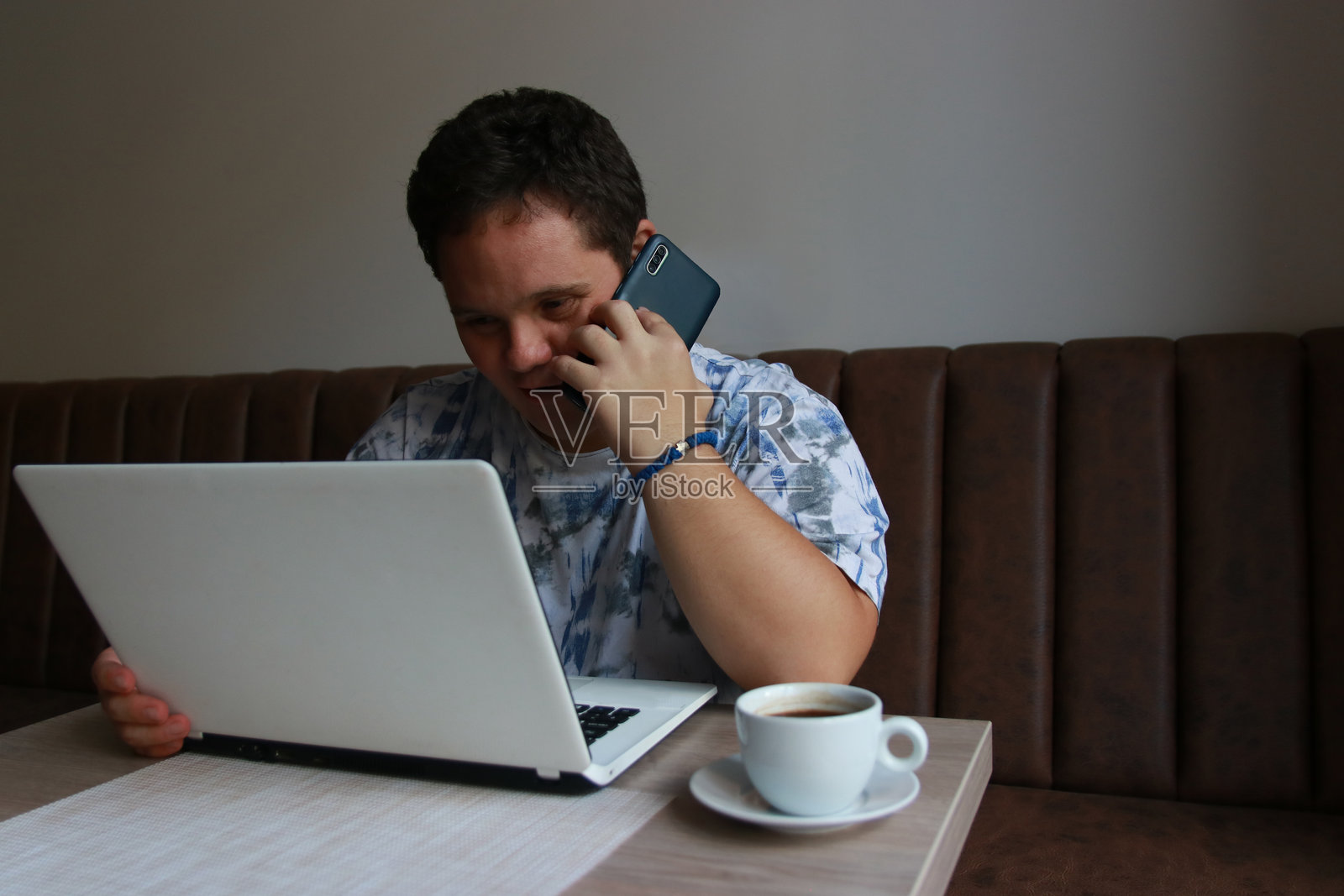 在咖啡馆在线工作的唐氏综合征年轻男人照片摄影图片