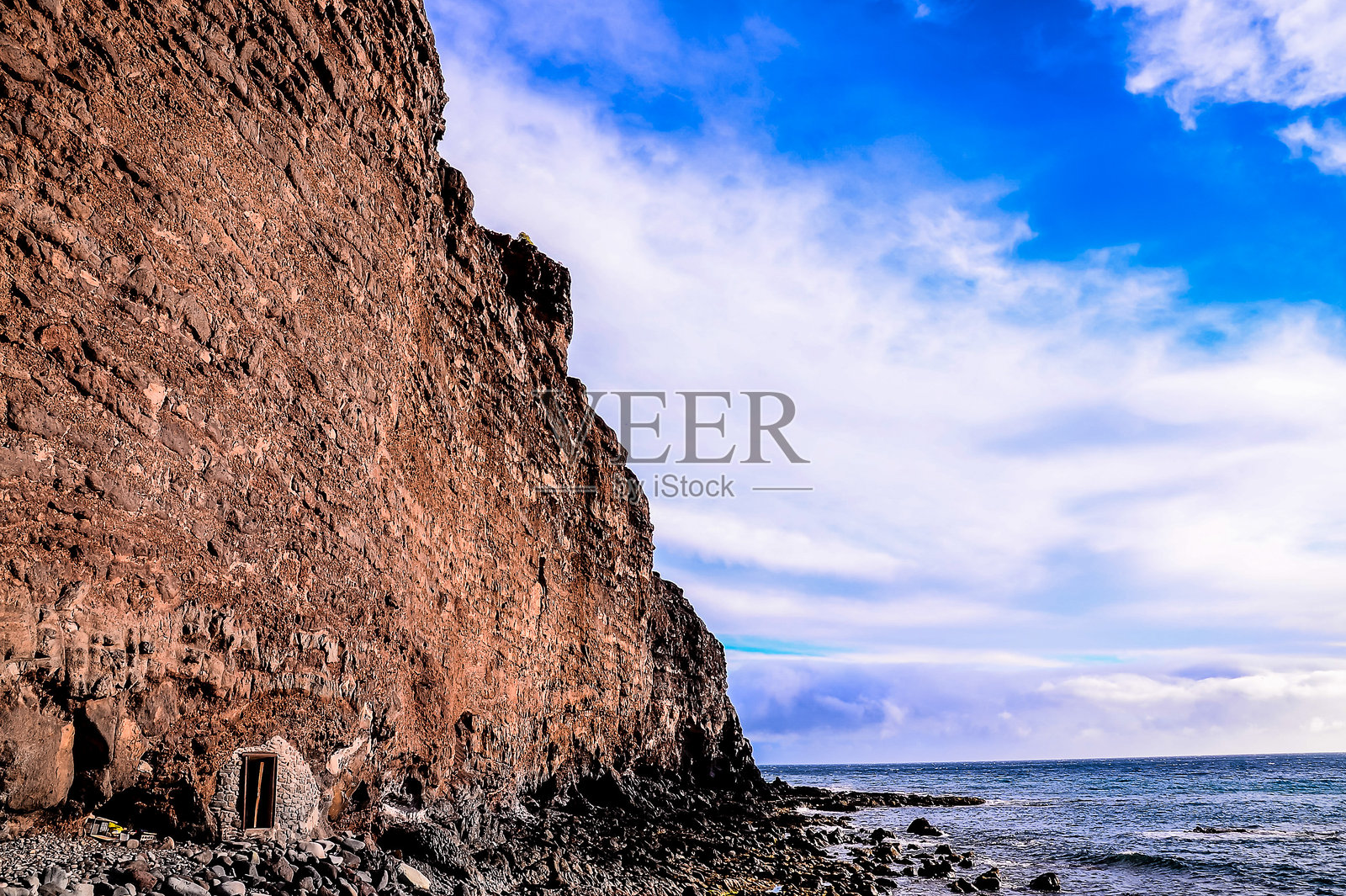 一座岩石悬崖俯瞰着海洋照片摄影图片