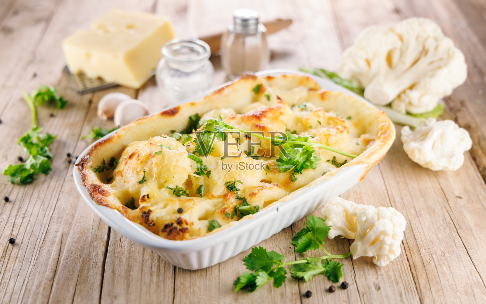 烤花椰菜奶酪焗饭，配料摆放在木质表面。非常适合健康餐和舒适的烘焙美食。照片摄影图片
