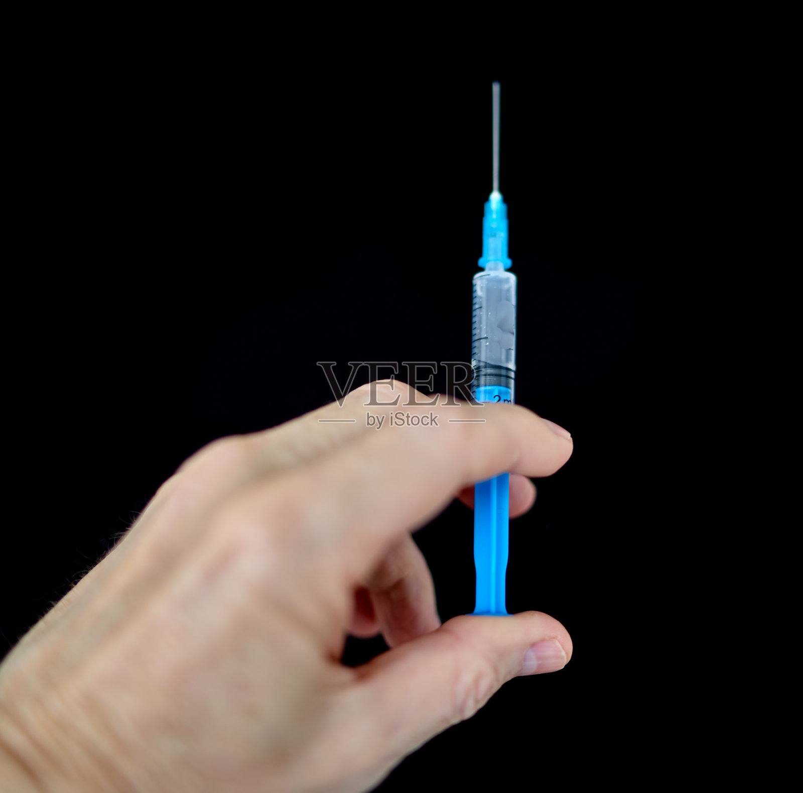 人手握着注射器照片摄影图片