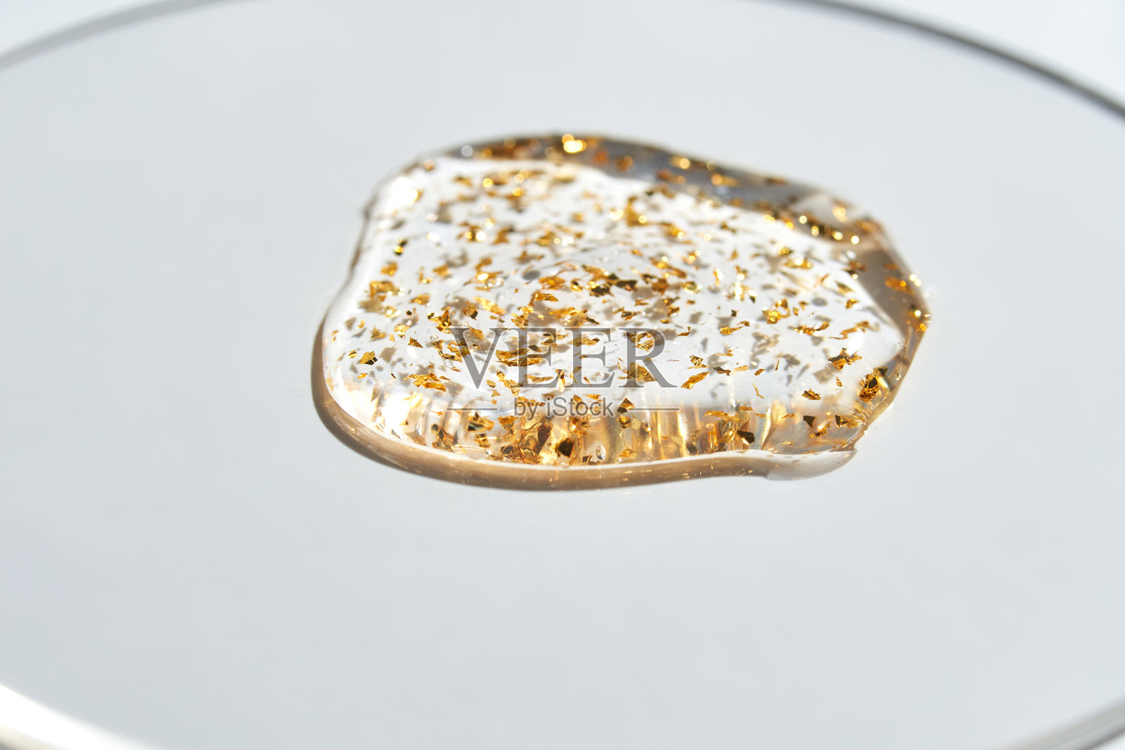 白色背景上的金色薄片凝胶，简约地捕捉优雅与魅力照片摄影图片