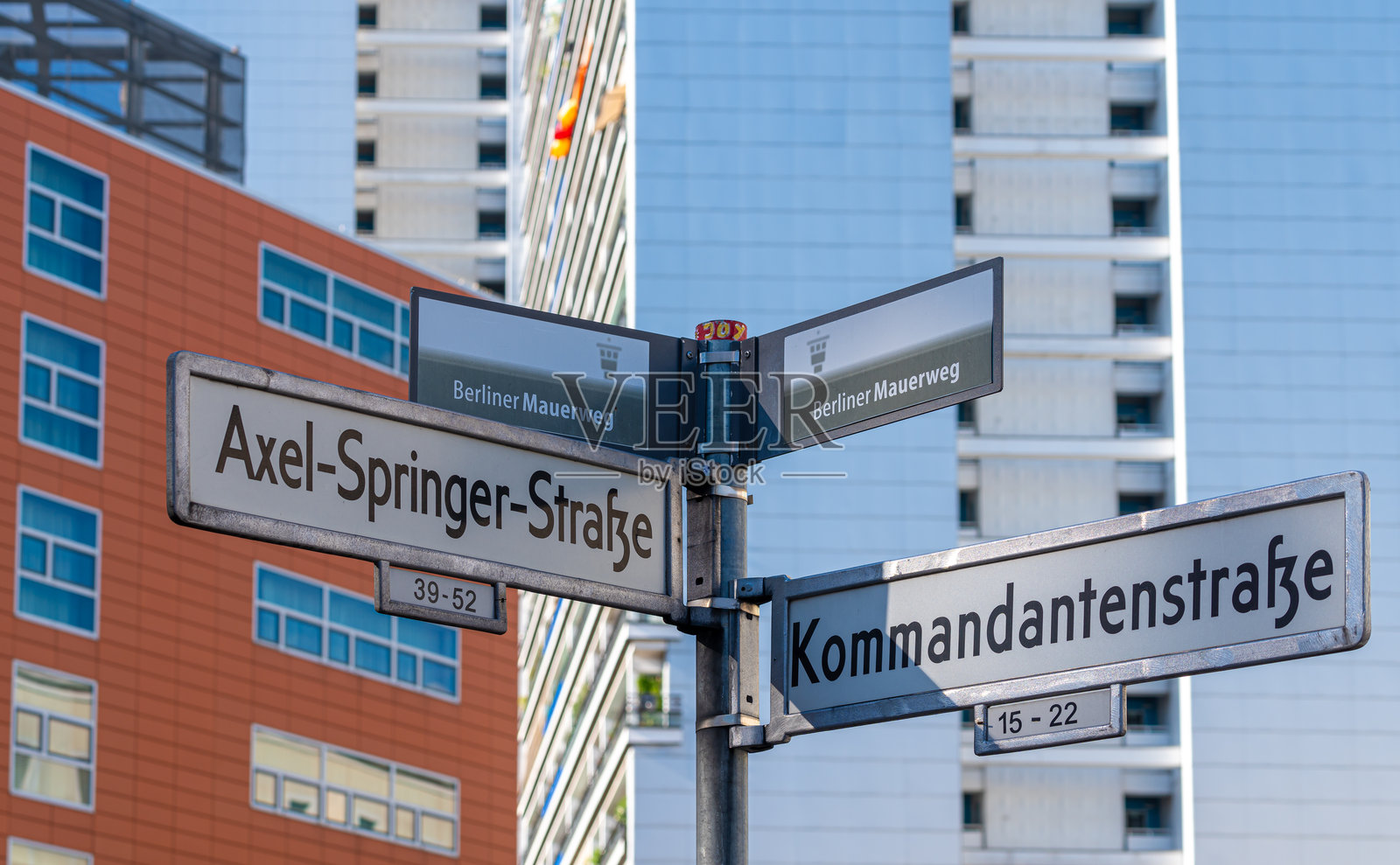 街道标志阿克塞尔-施普林格-斯特拉斯街和柏林墙道路对面的建筑物照片摄影图片