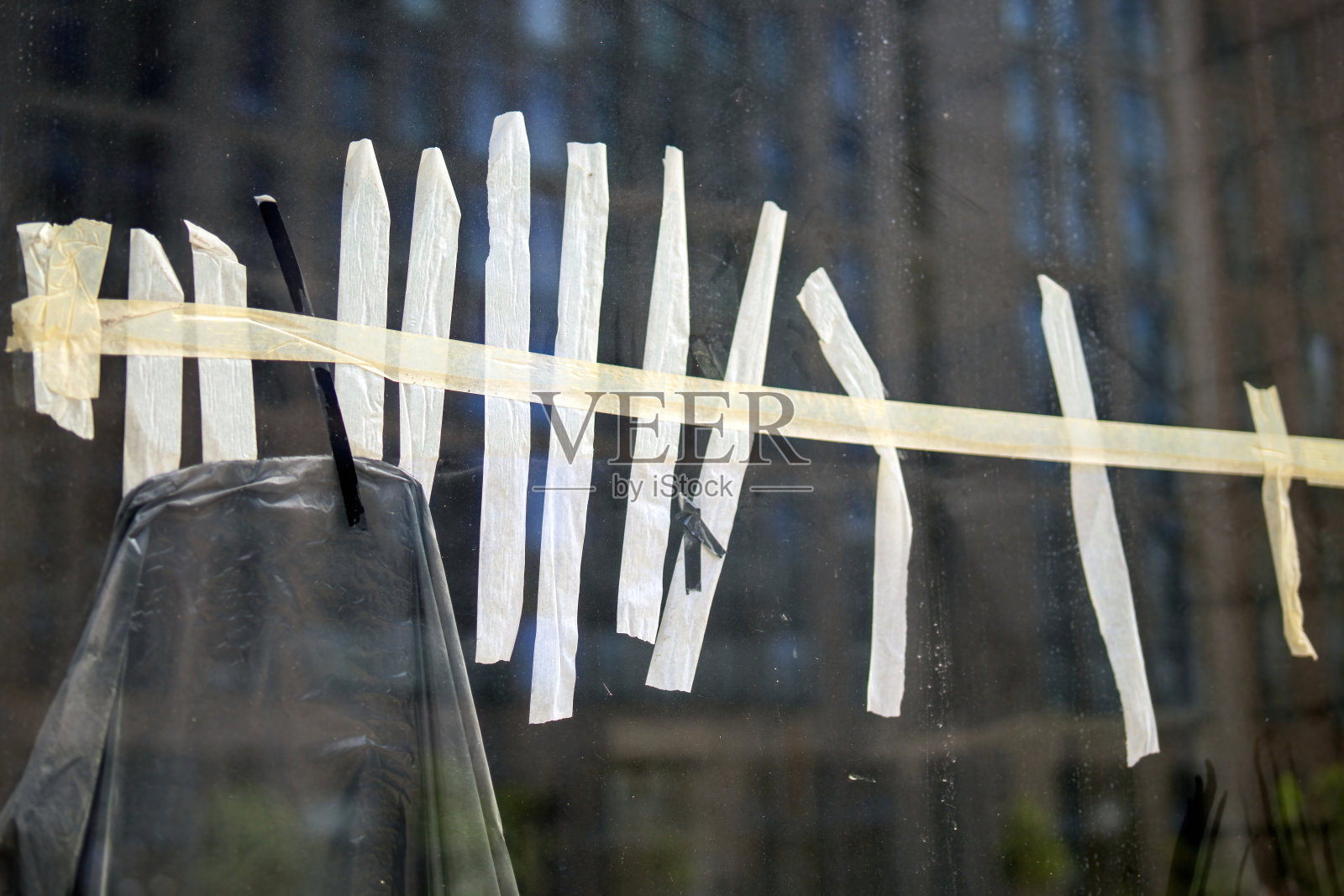 用平行条纹遮蔽胶带装饰的窗格。该胶带用作保护屏障，通过固定保护膜来保护隐私照片摄影图片