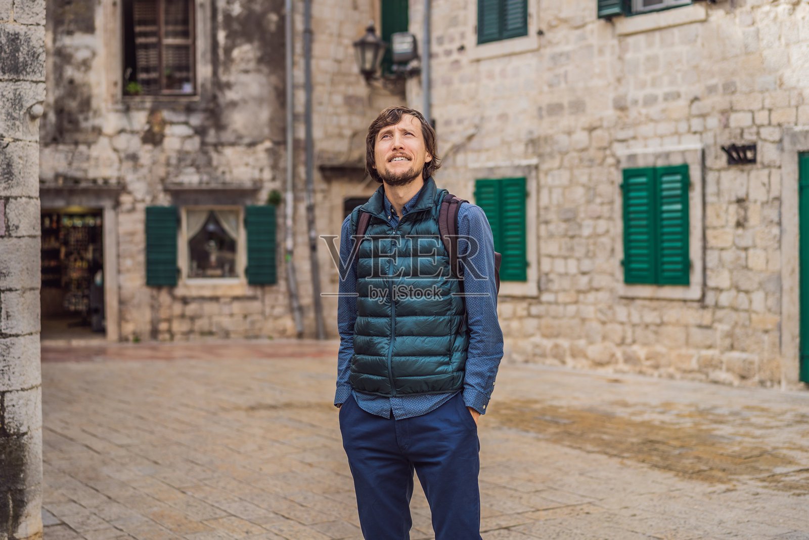 男子游客在阳光明媚的日子里享受黑山科托尔老城的多彩街道。黑山旅行概念照片摄影图片