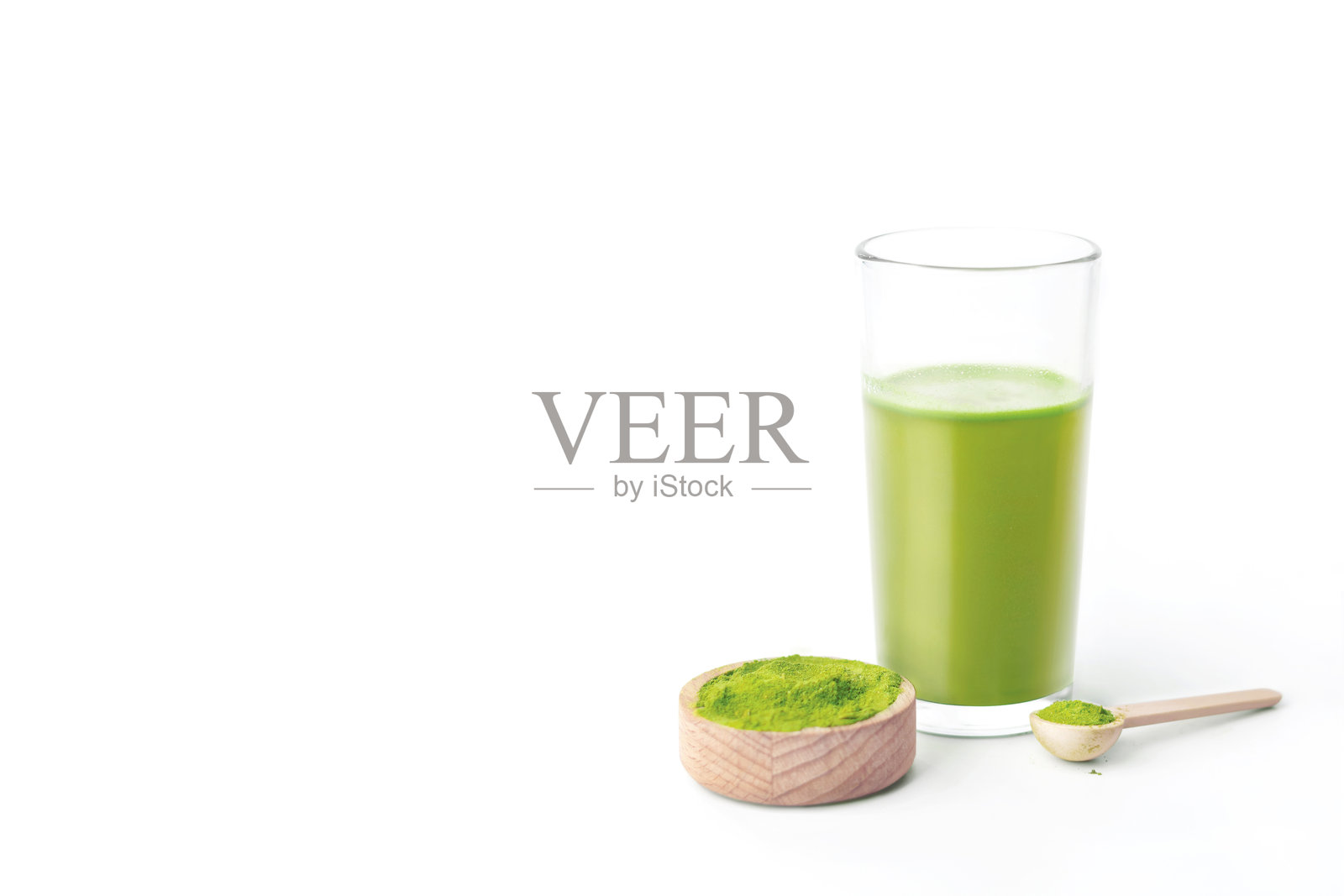 白色背景下的鲜榨小麦草汁玻璃杯，留有空白空间照片摄影图片