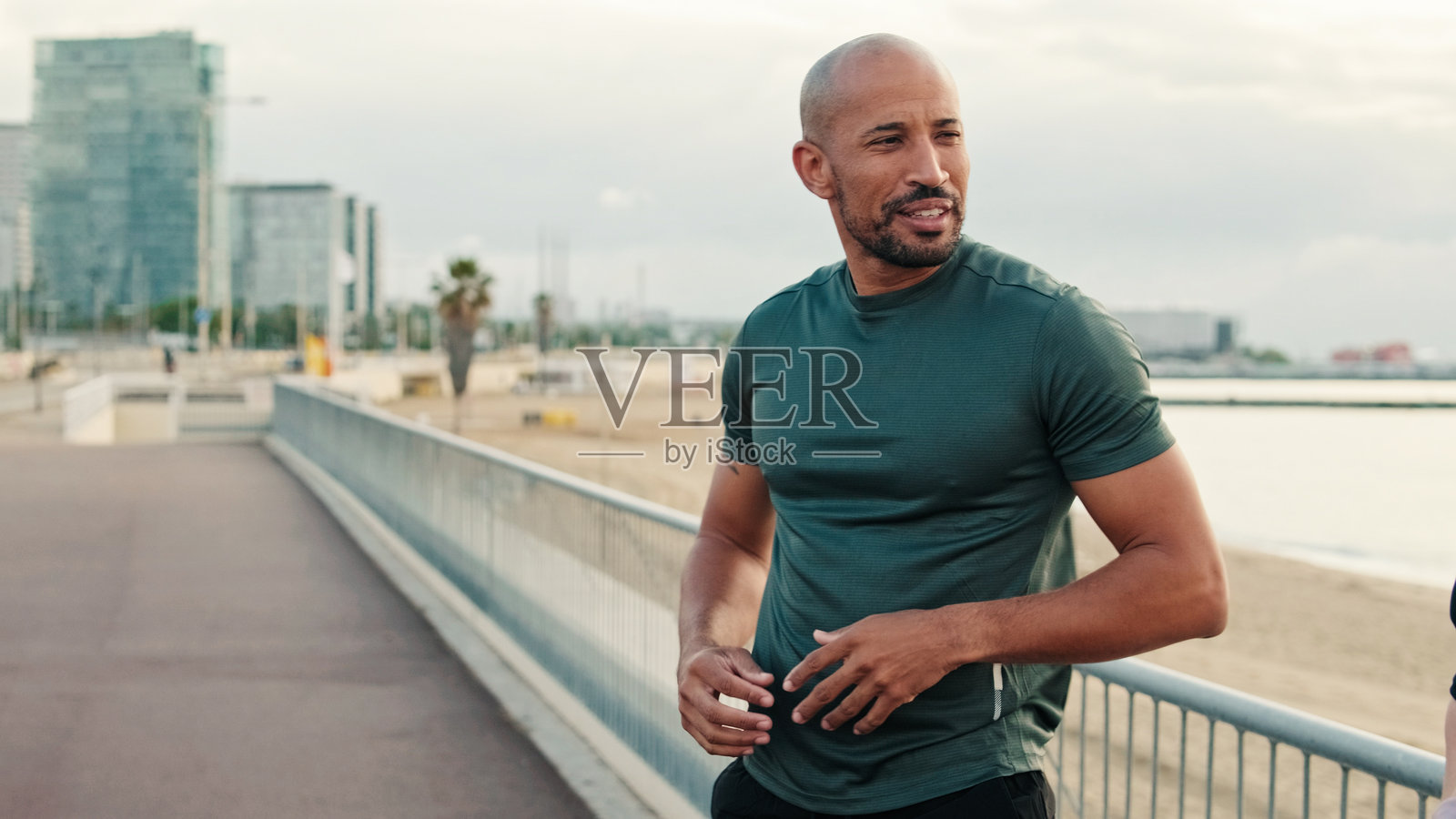 户外拉伸训练，年轻健壮的男子在海边锻炼照片摄影图片