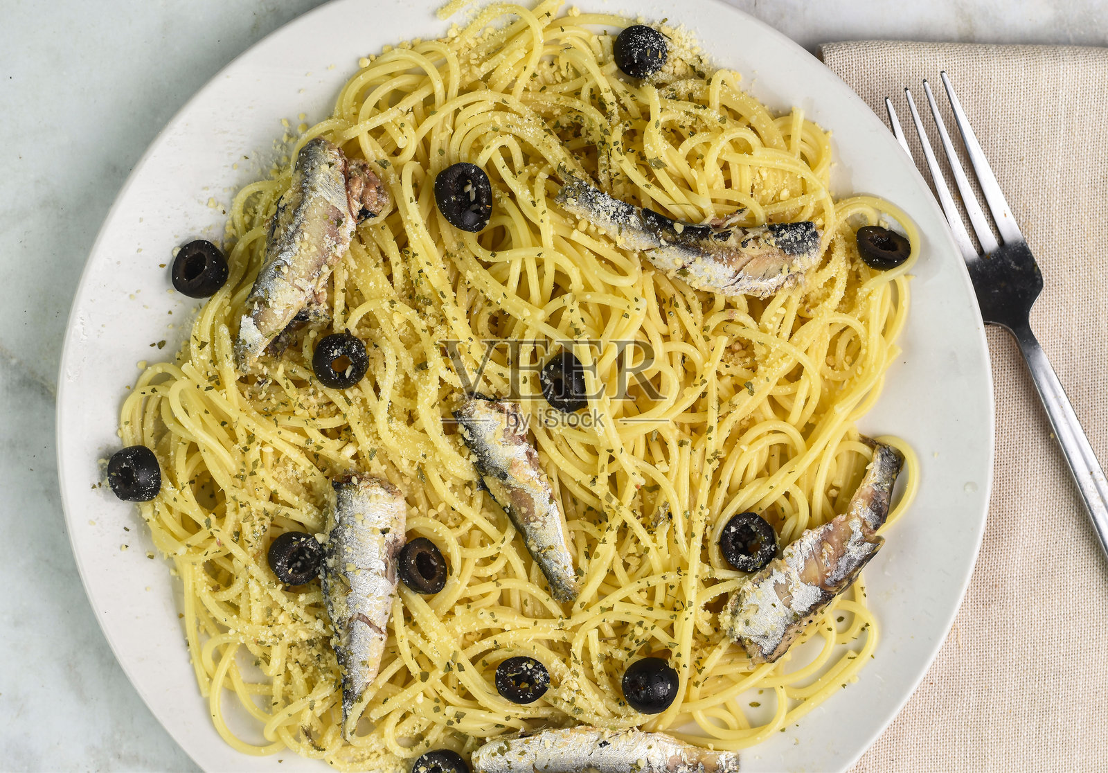 意大利面圈顶部配沙丁鱼和黑橄榄照片摄影图片