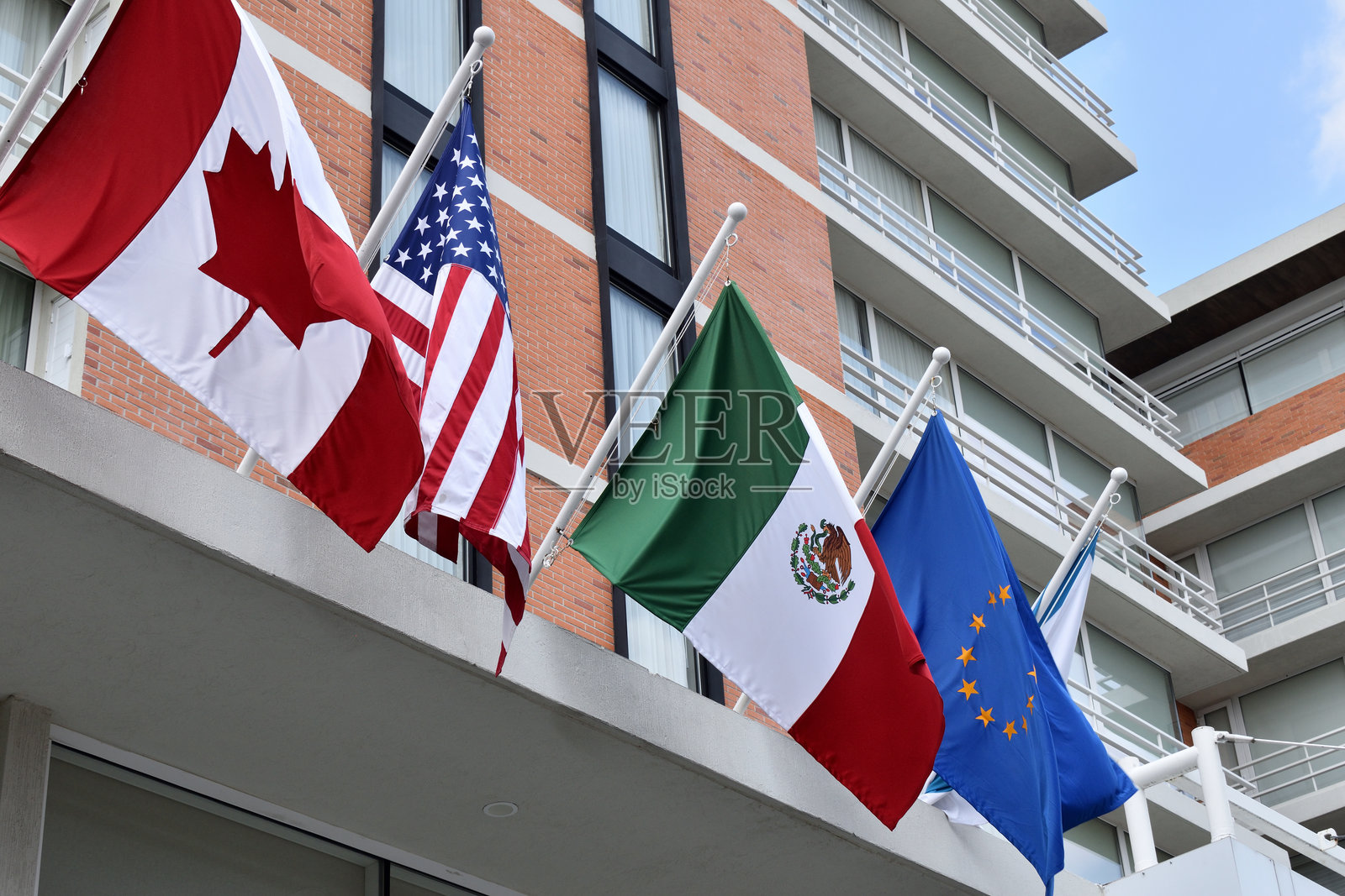 四面旗帜悬挂在建筑物上，包括美国国旗和加拿大国旗照片摄影图片