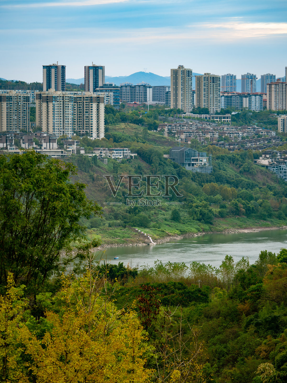 城市山丘上的高层建筑，宽阔的河流照片摄影图片