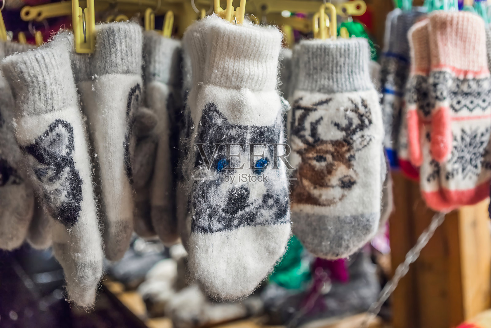 温暖的动物图案针织手套在市场摊位上出售。照片摄影图片