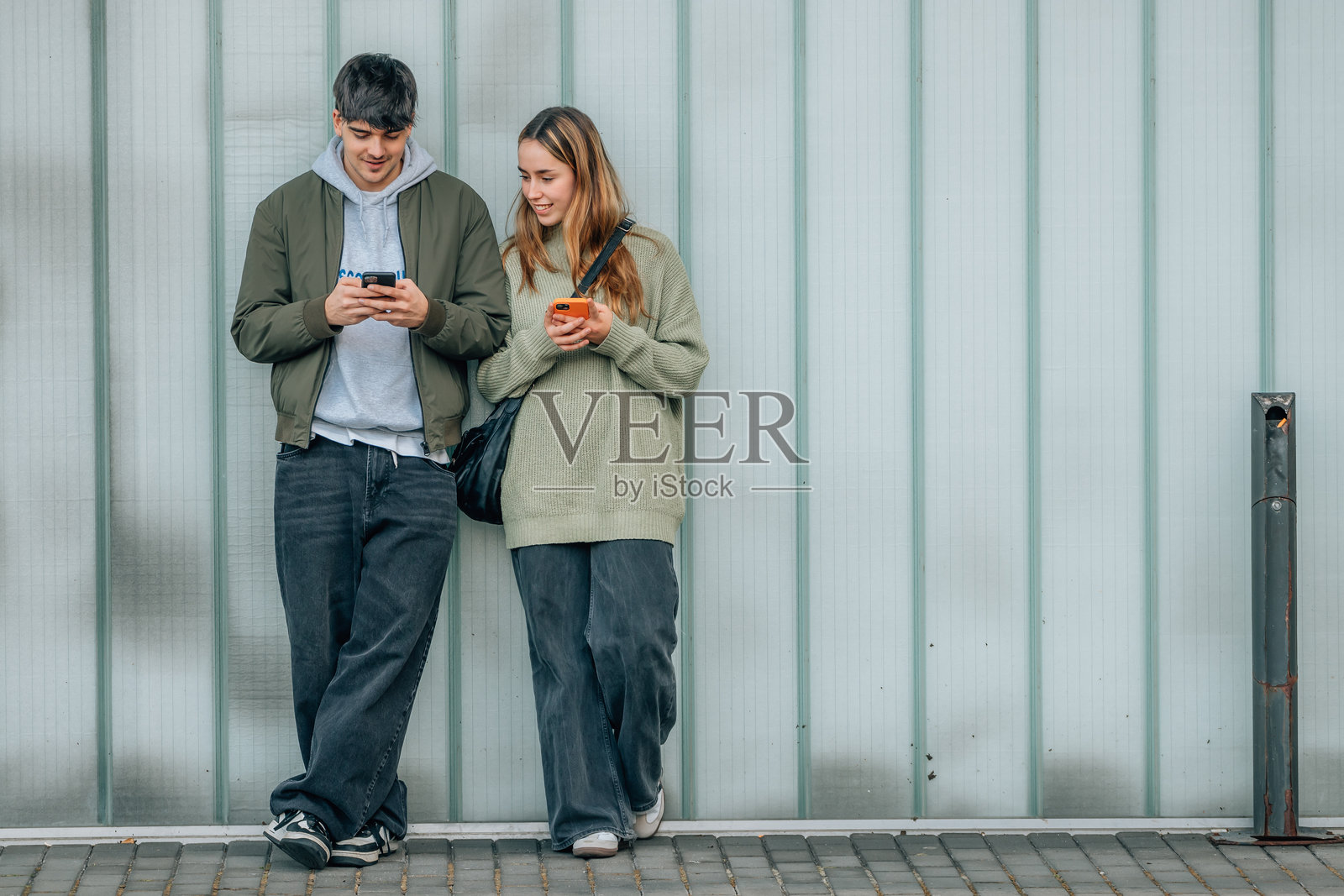 街头使用手机的都市年轻情侣照片摄影图片