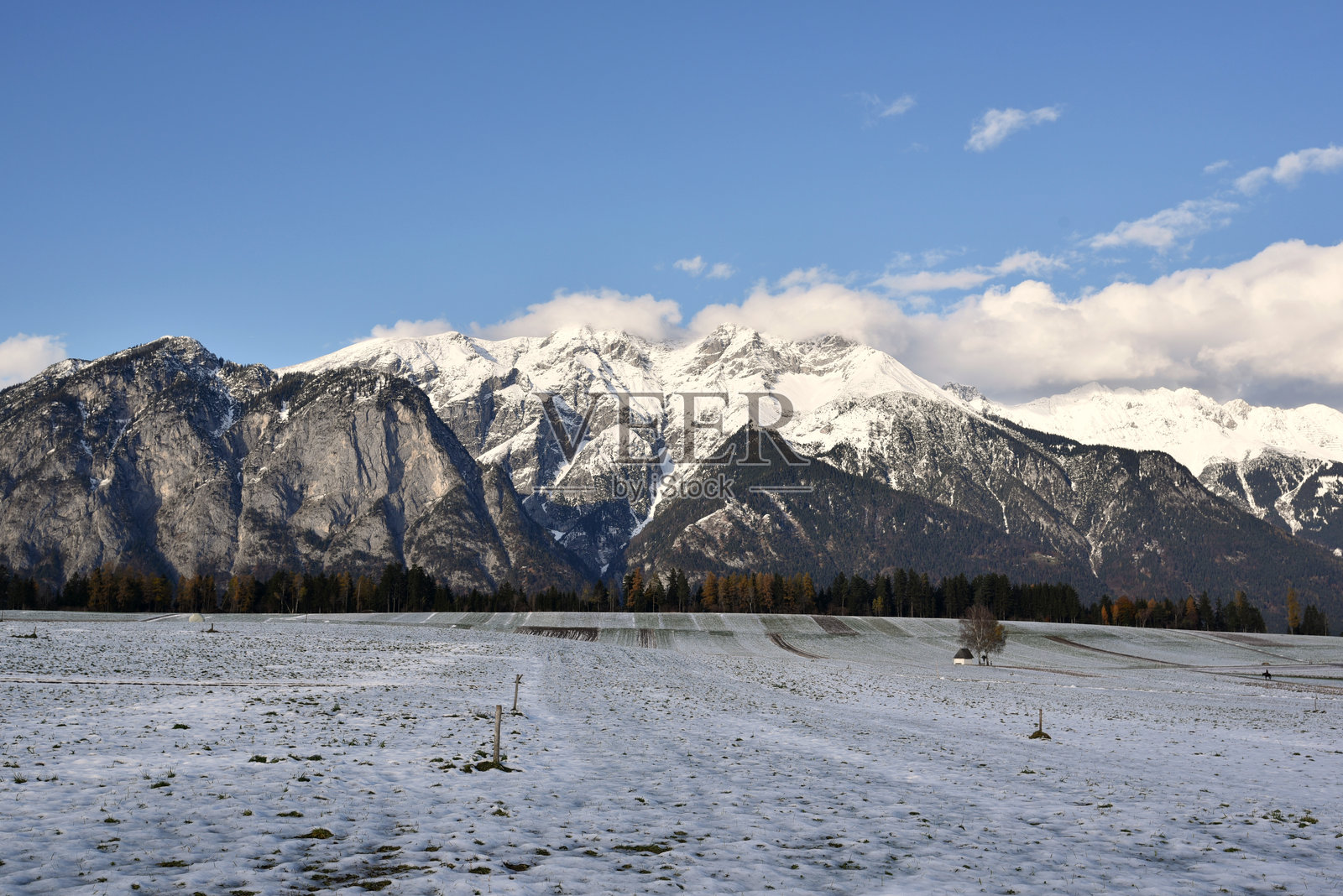 在蒂罗尔州的戈岑斯，雪覆盖的田野和远处的山脉照片摄影图片