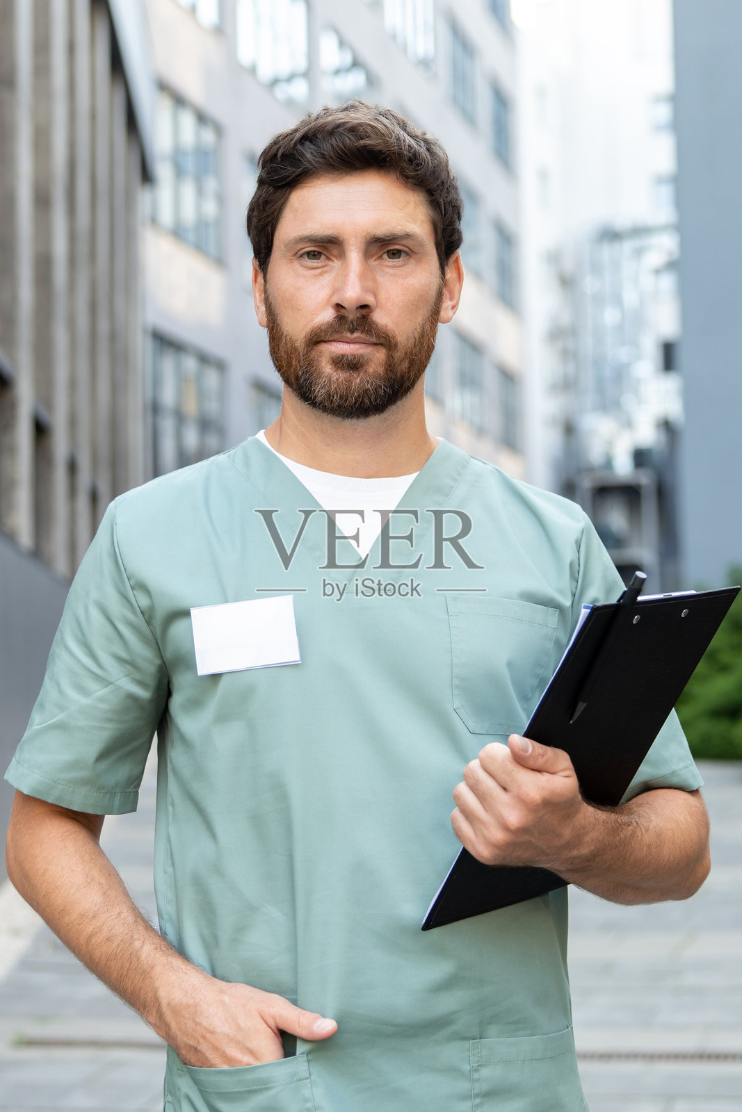 穿着制服的男医生在现代诊所户外填写医疗表格照片摄影图片