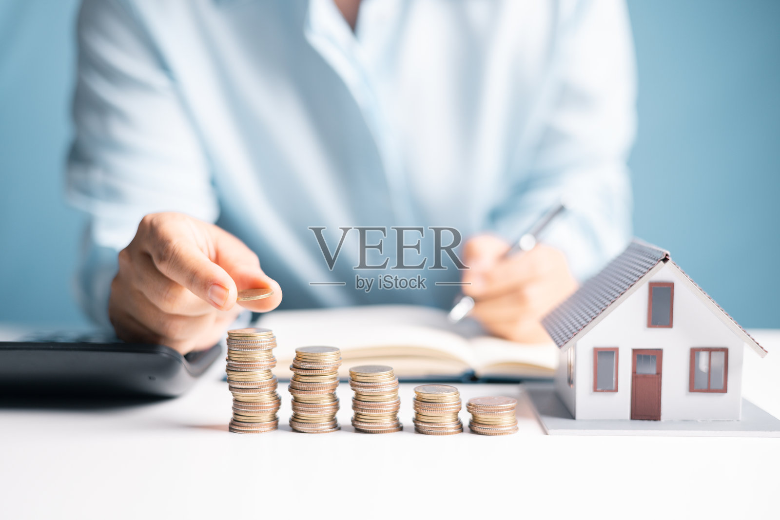 女人决定通过明智地管理财务来存钱买房，并将她的家视为未来商业投资的重要组成部分。照片摄影图片