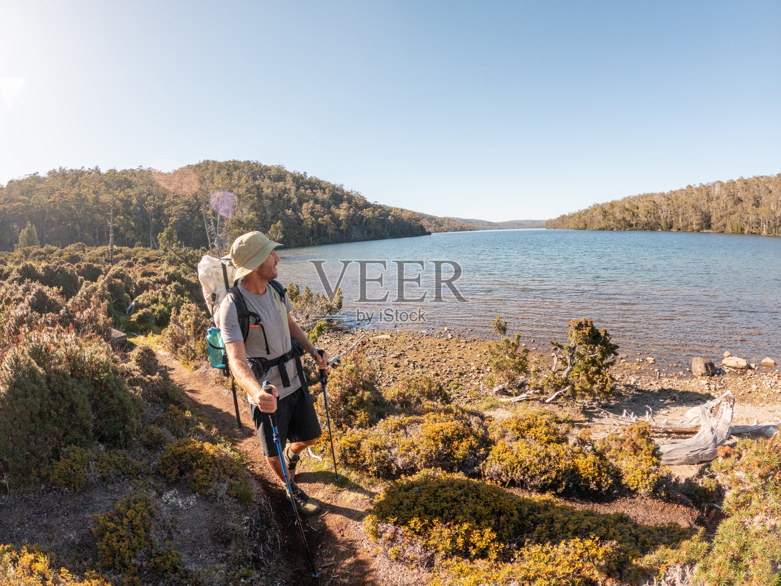 登山者在山间小径上欣赏风景如画的湖景照片摄影图片