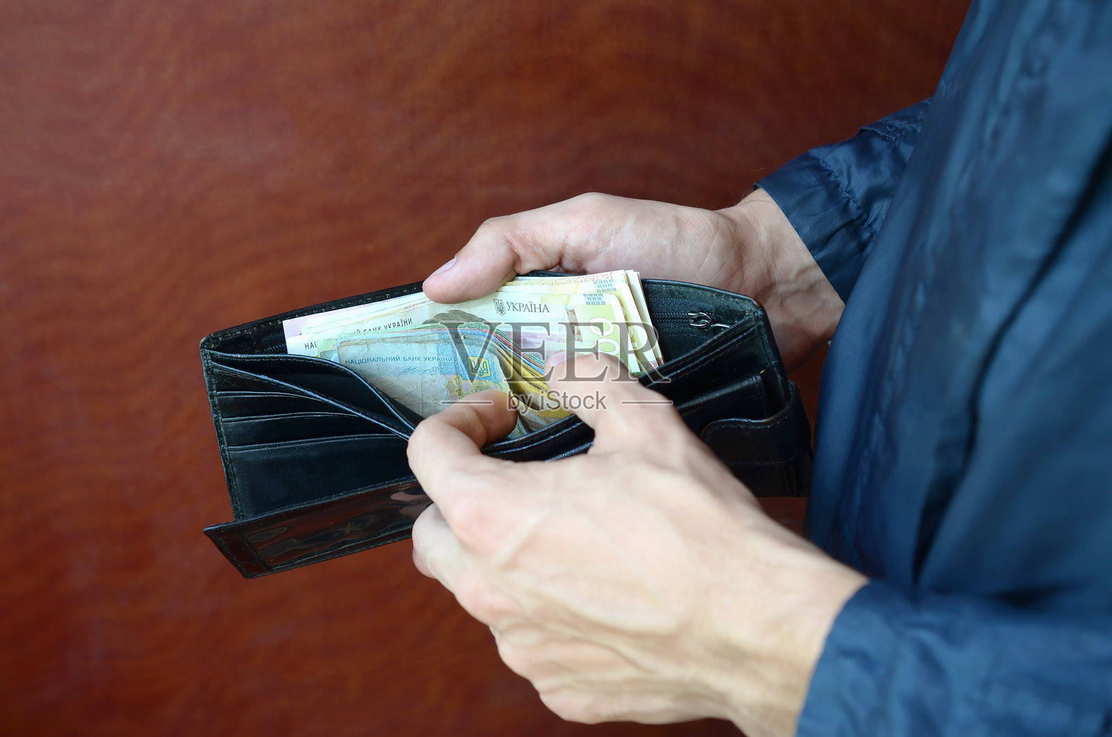 男子中部握着装有纸币的钱包照片摄影图片