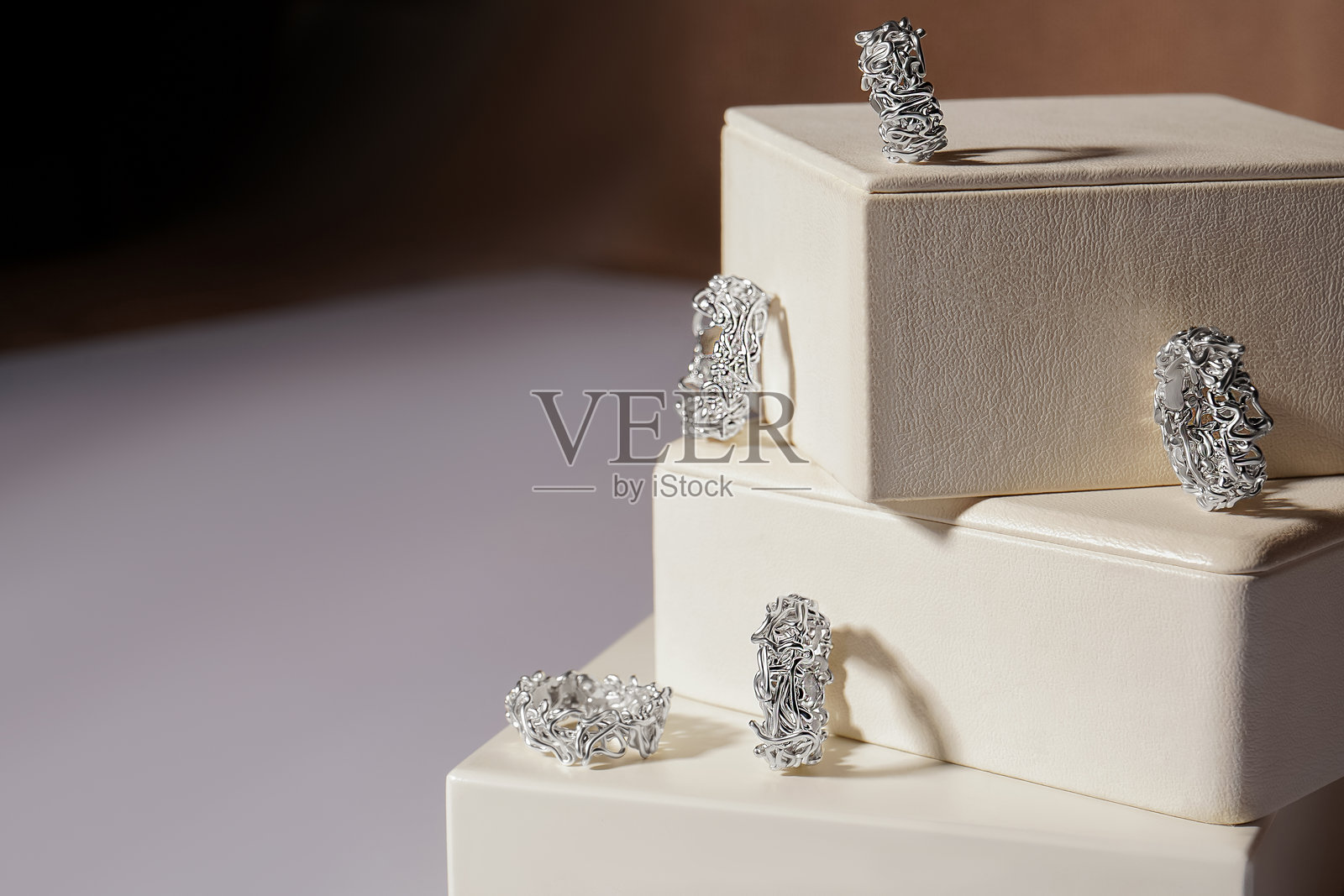 带有宝石的珠宝。用银和石头制作的珠宝放在纸盒里。用金属编织而成的戒指。照片摄影图片