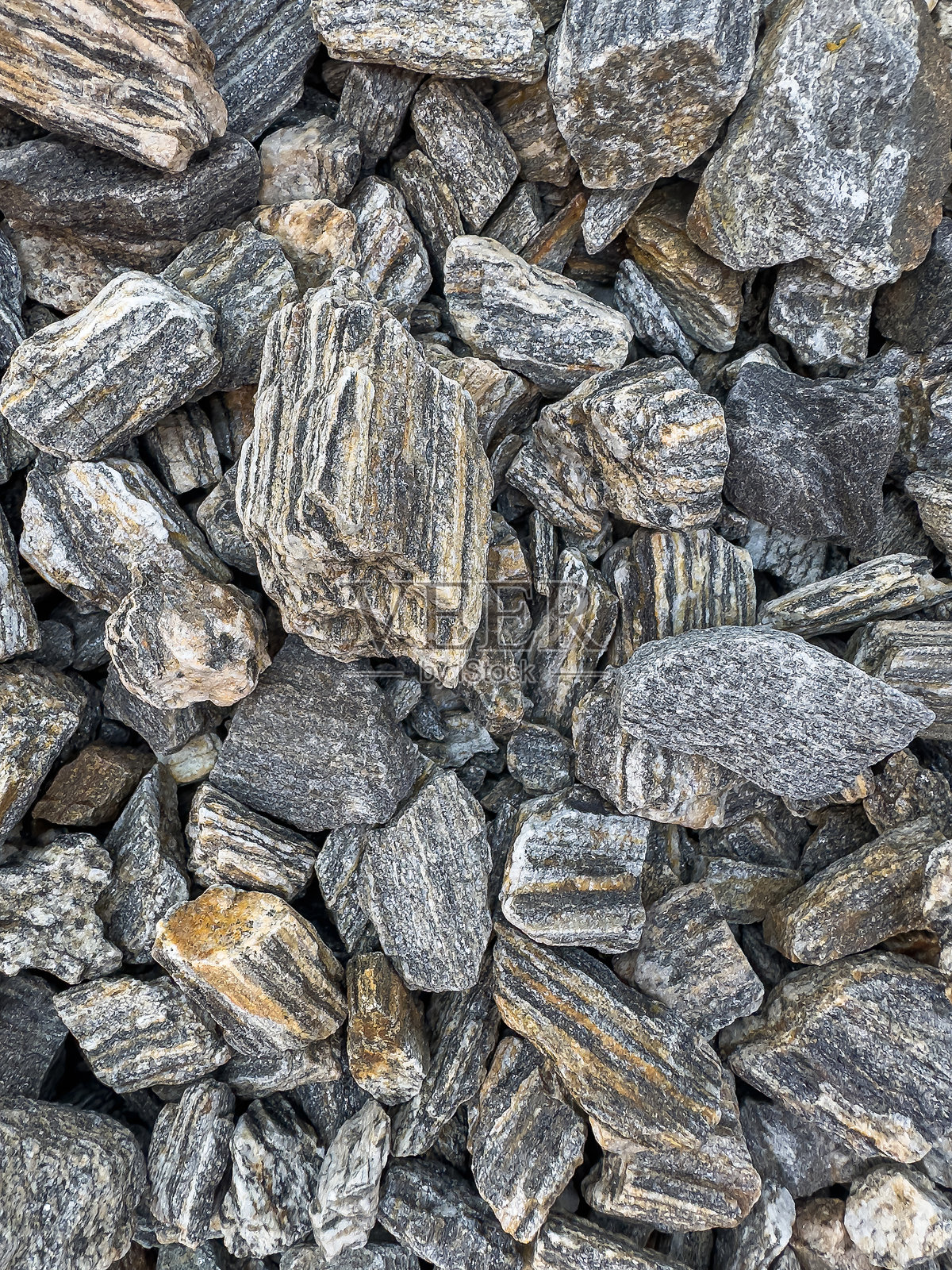 灰色自然光滑的卵石作为纹理或背景，花园床中的卵石照片摄影图片