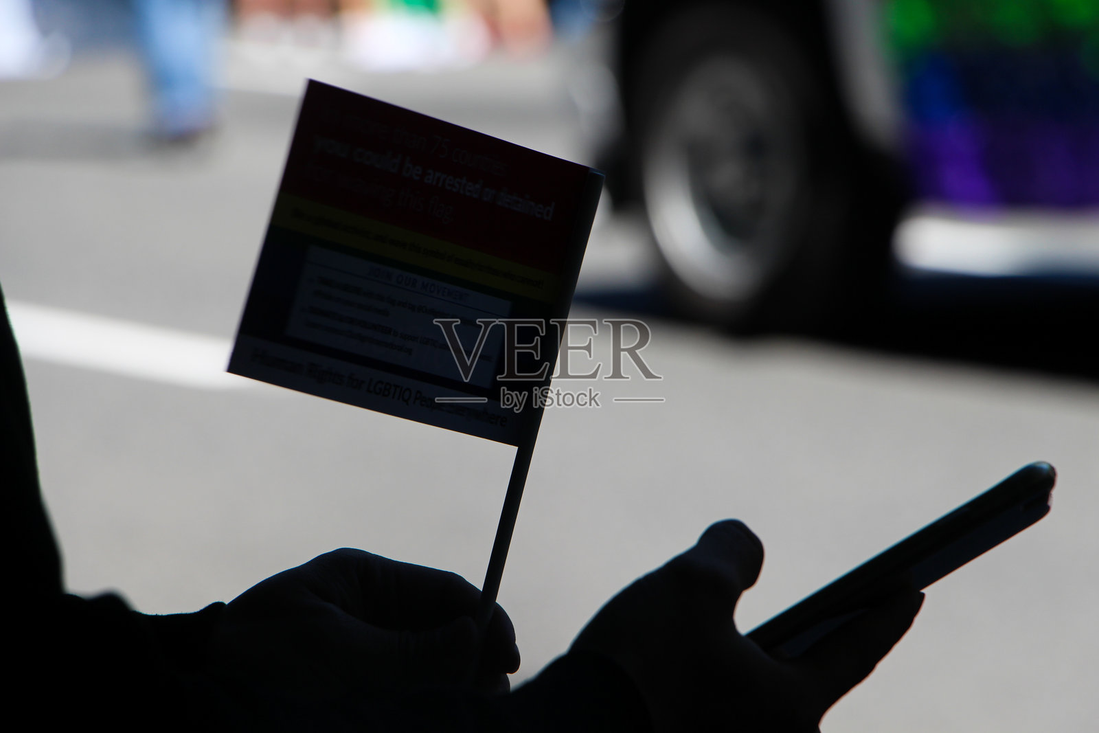 城市中手持旗帜和手机的剪影照片摄影图片