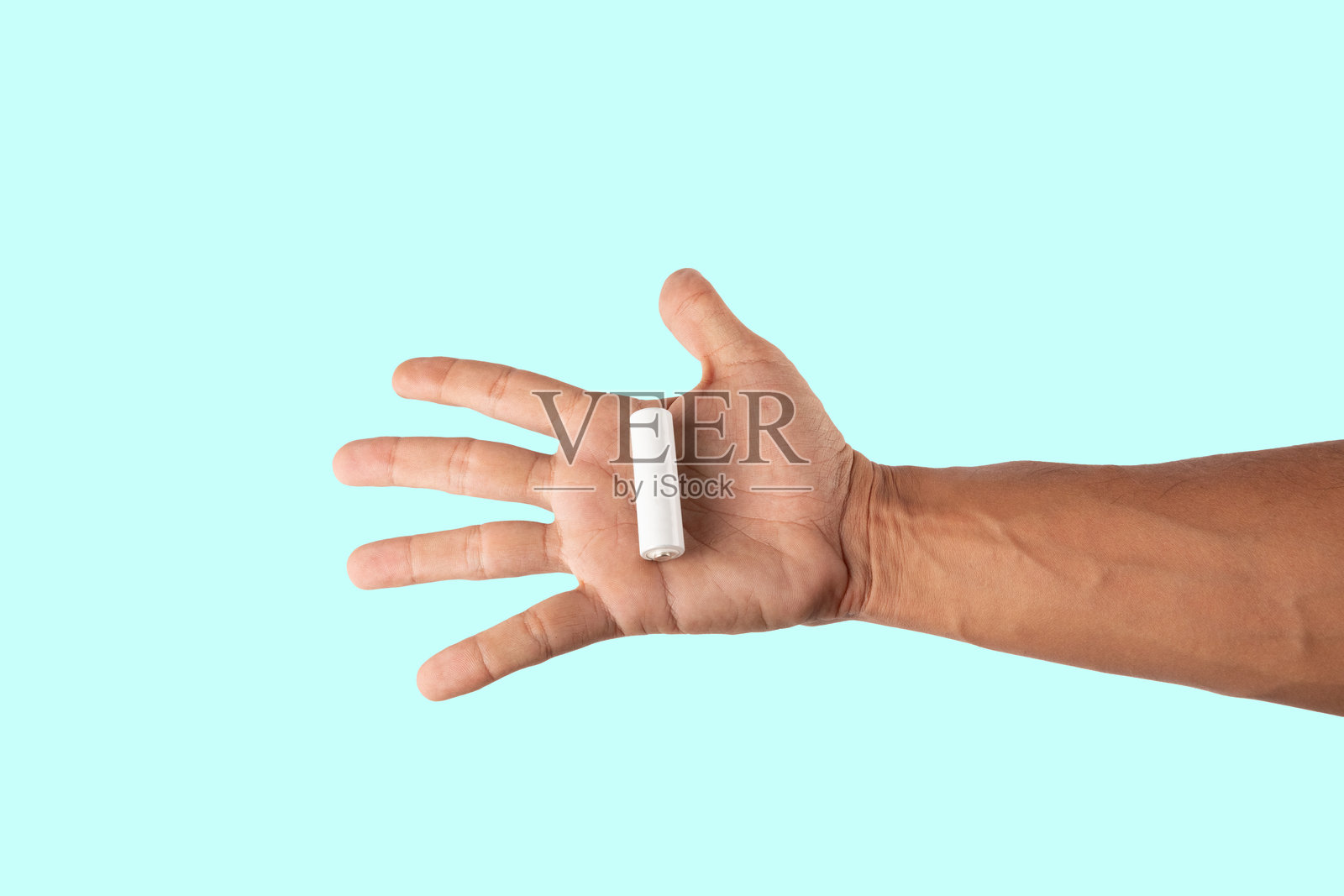 男性手握着白色电池单元模型，背景为青色。照片摄影图片