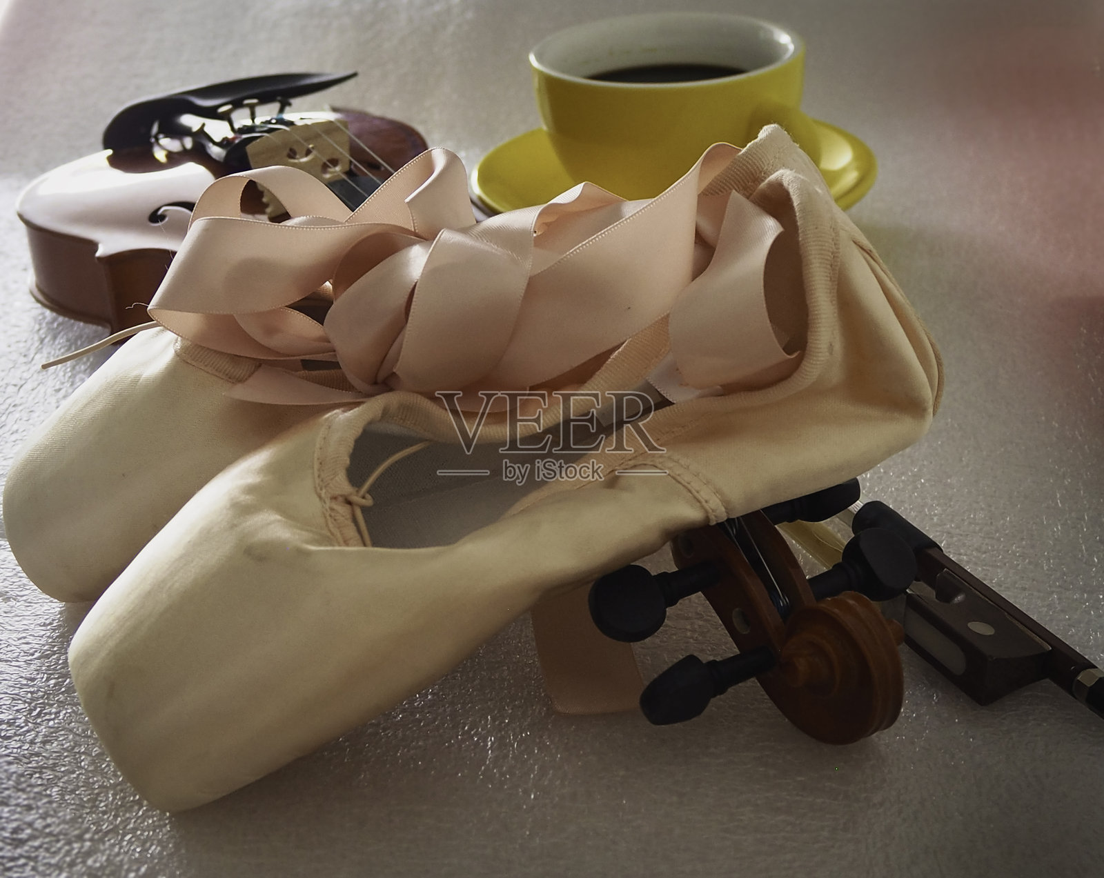 粉色缎面芭蕾舞鞋放在木制小提琴上照片摄影图片