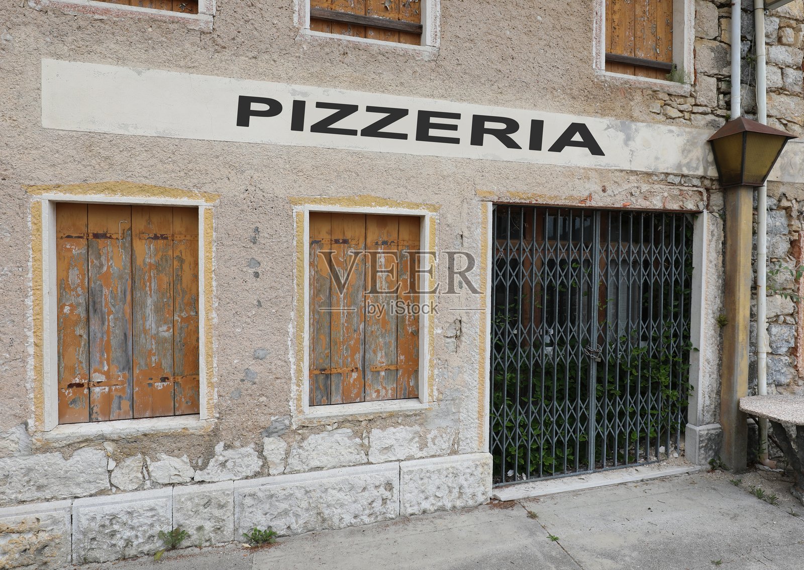 城市中一家披萨店的招牌，上面写着“披萨店”，因经济危机而关闭。照片摄影图片