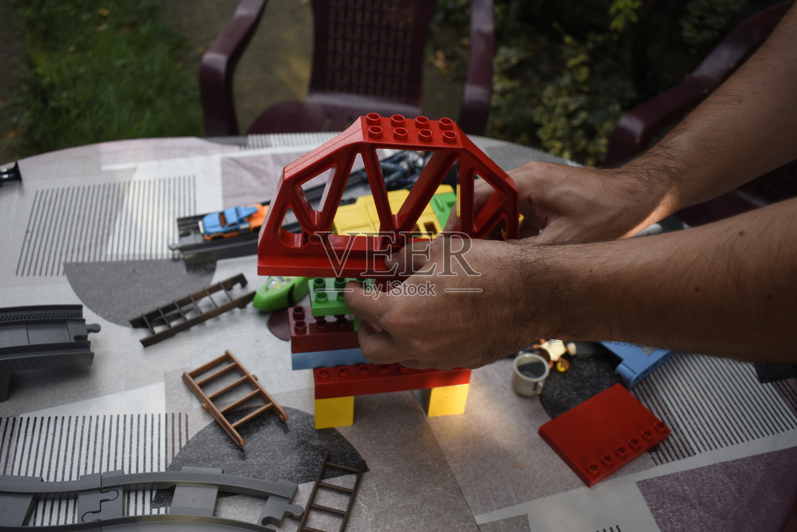 一名男子在花园的桌子上组装玩具照片摄影图片