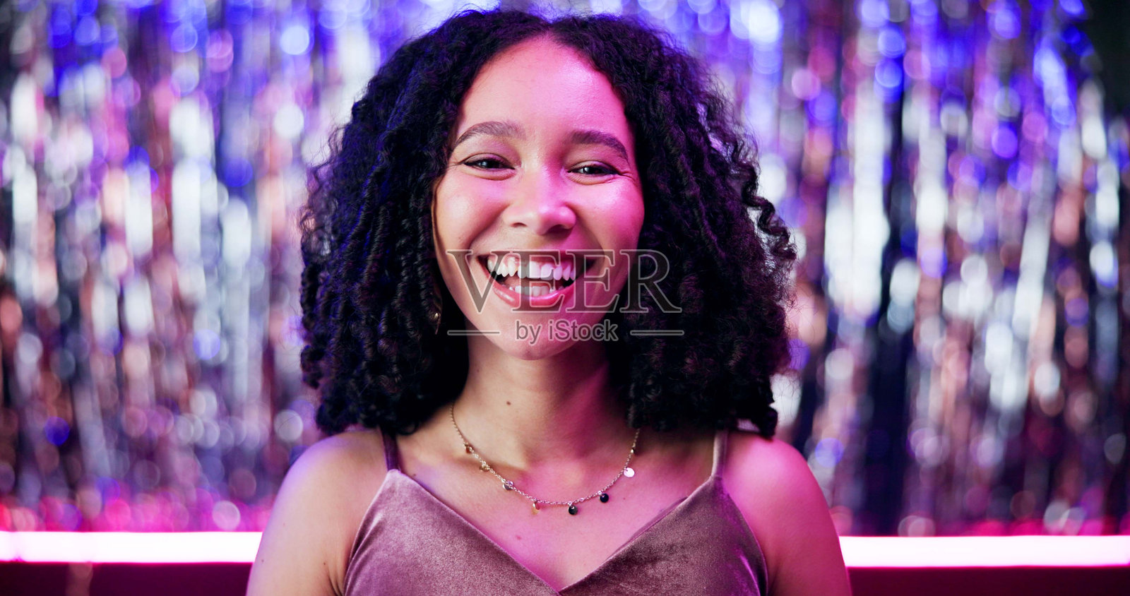 微笑，夜总会和派对上女性的肖像，霓虹灯光下庆祝或娱乐活动。快乐、自信的女性在狂欢、迪斯科或DJ演出中的面孔，展现娱乐氛围。照片摄影图片