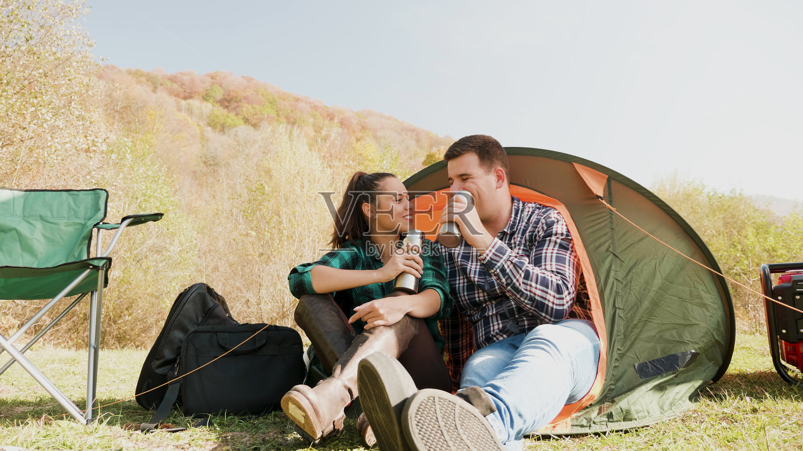 一对情侣在露营帐篷前一起享受饮品照片摄影图片