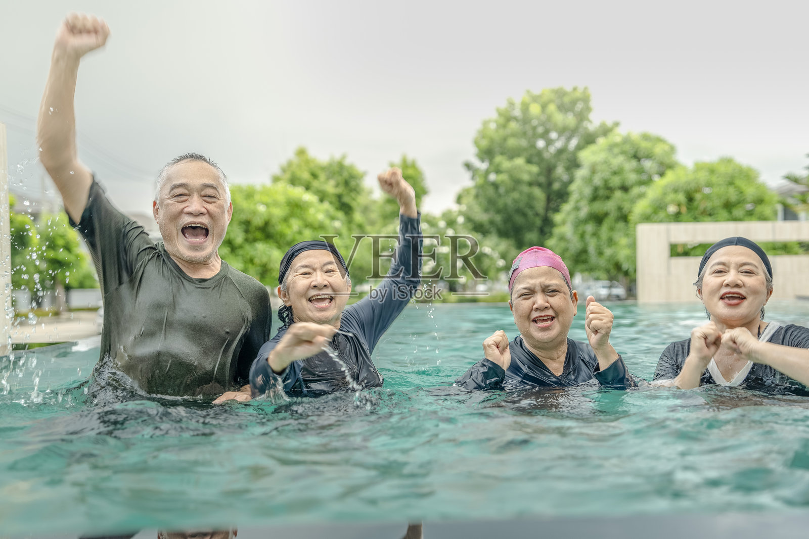 人们在游泳池中享受有趣的水上活动，开心地玩着球类游戏，笑声不断。这个场景强调了健康、积极的生活方式和户外社交互动。照片摄影图片