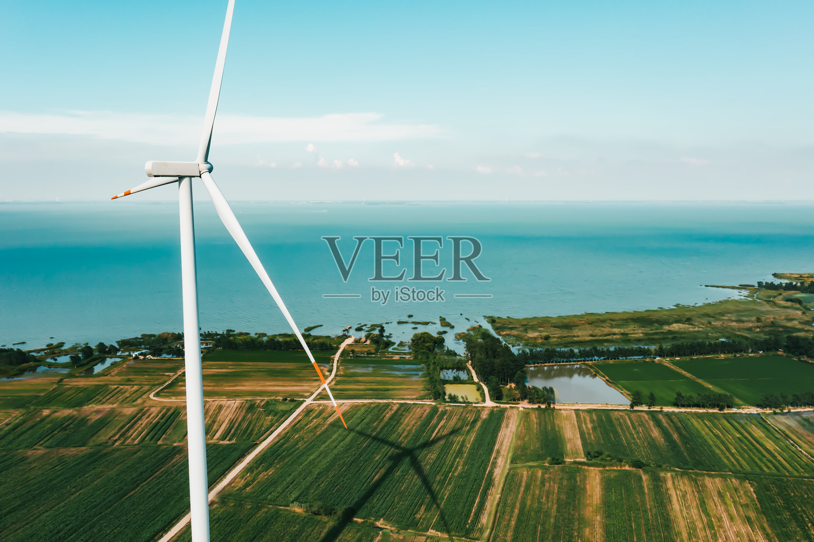 湖边绿地上的风力涡轮机鸟瞰图照片摄影图片