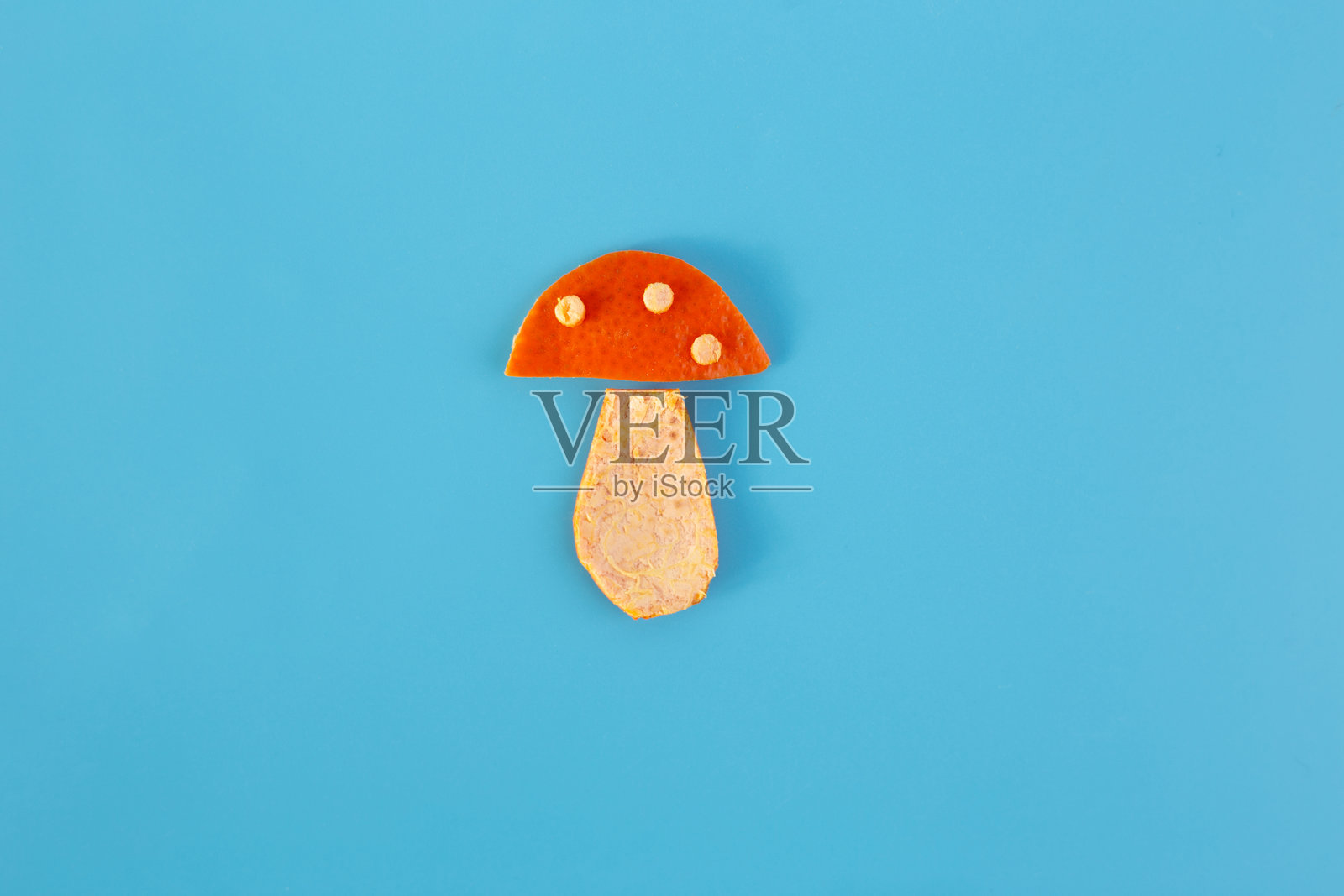 DIY，橘子皮制作的蘑菇工艺品，蓝色背景照片摄影图片