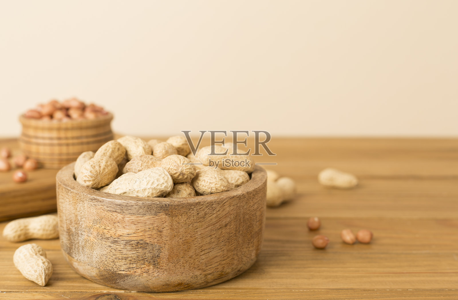 剥壳和未剥壳的花生放在木桌上照片摄影图片