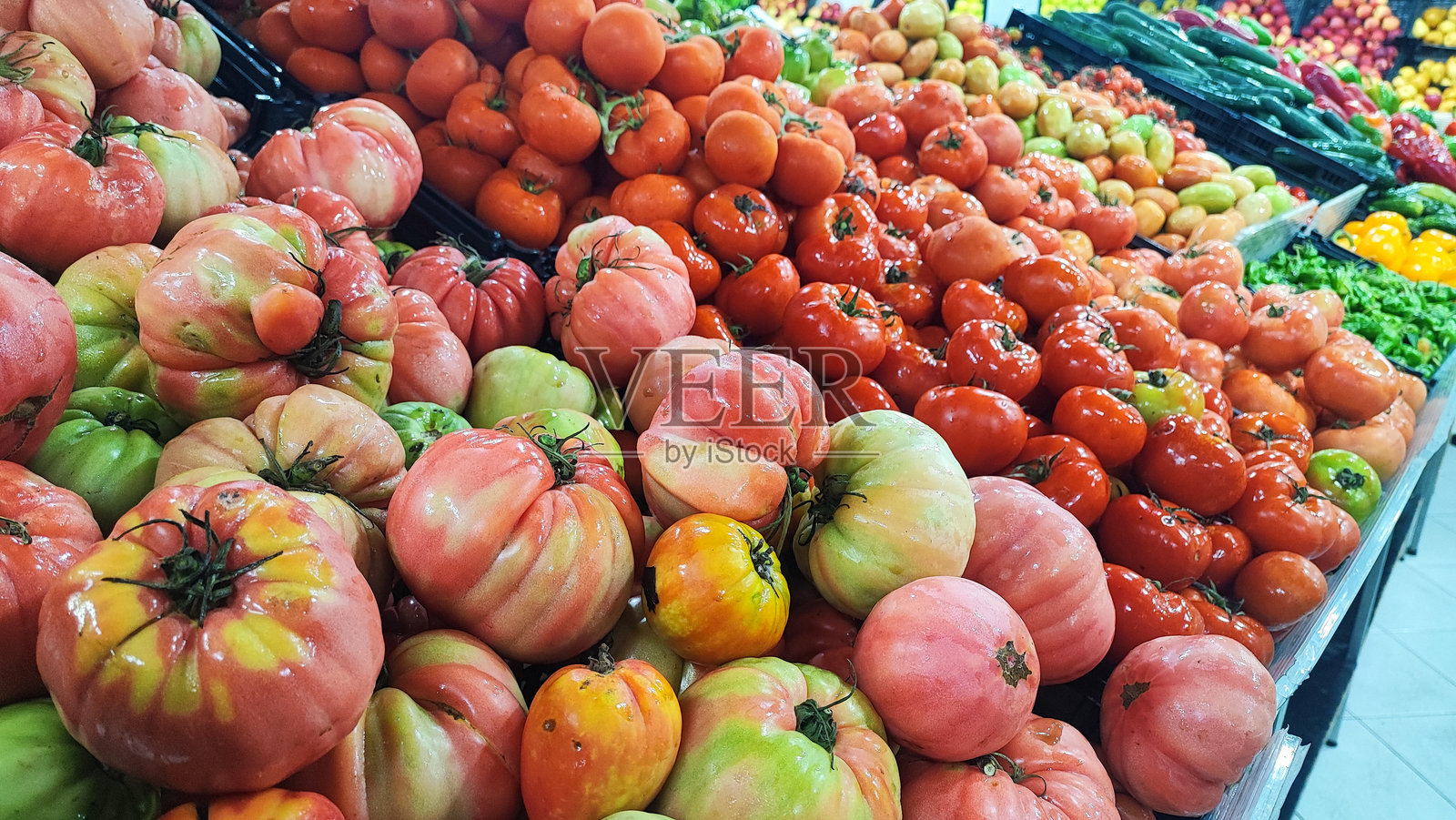 一组异国情调的热带蔬菜，如红薯、生姜、茄子、舒莎、姜番茄和黄瓜，展示在葡萄牙马德拉岛的食品市场上。照片摄影图片