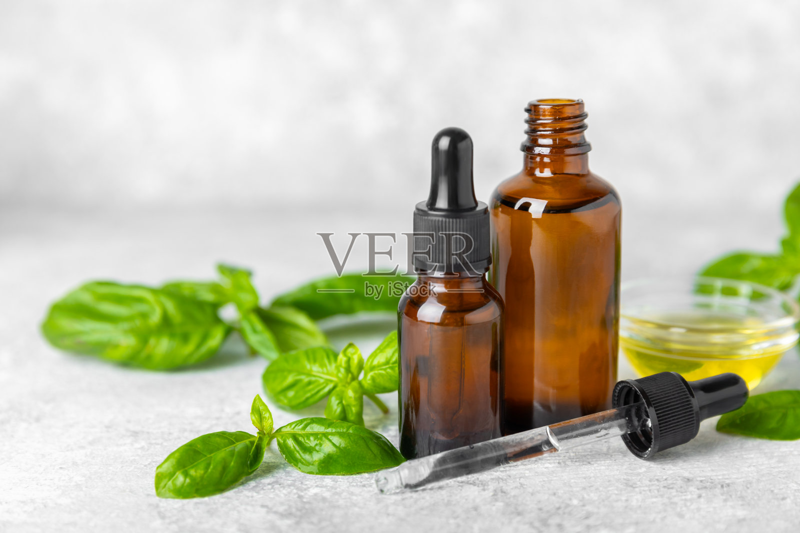 罗勒精油放在有纹理的木质背景上。罗勒精油和新鲜叶子。芳香疗法。香气油。药用草药。替代医学。留白处。文本空间。照片摄影图片