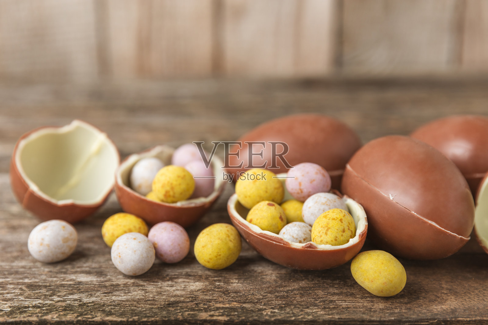 复活节巧克力蛋在纹理背景上。复活节庆祝概念。复活节巧克力兔。巧克力甜蛋。纹理木桌上的糖果。留白空间。礼物。横幅。照片摄影图片