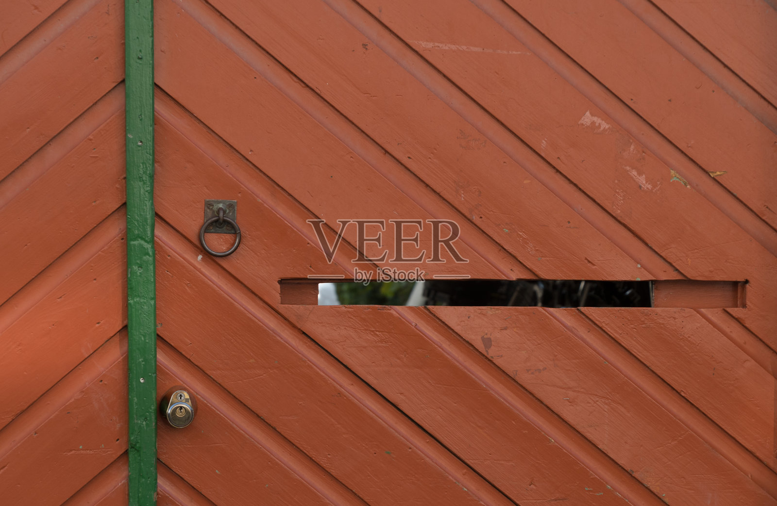 罗德洛卡的一座房子里，红色木门上有一个打开的邮件槽。照片摄影图片