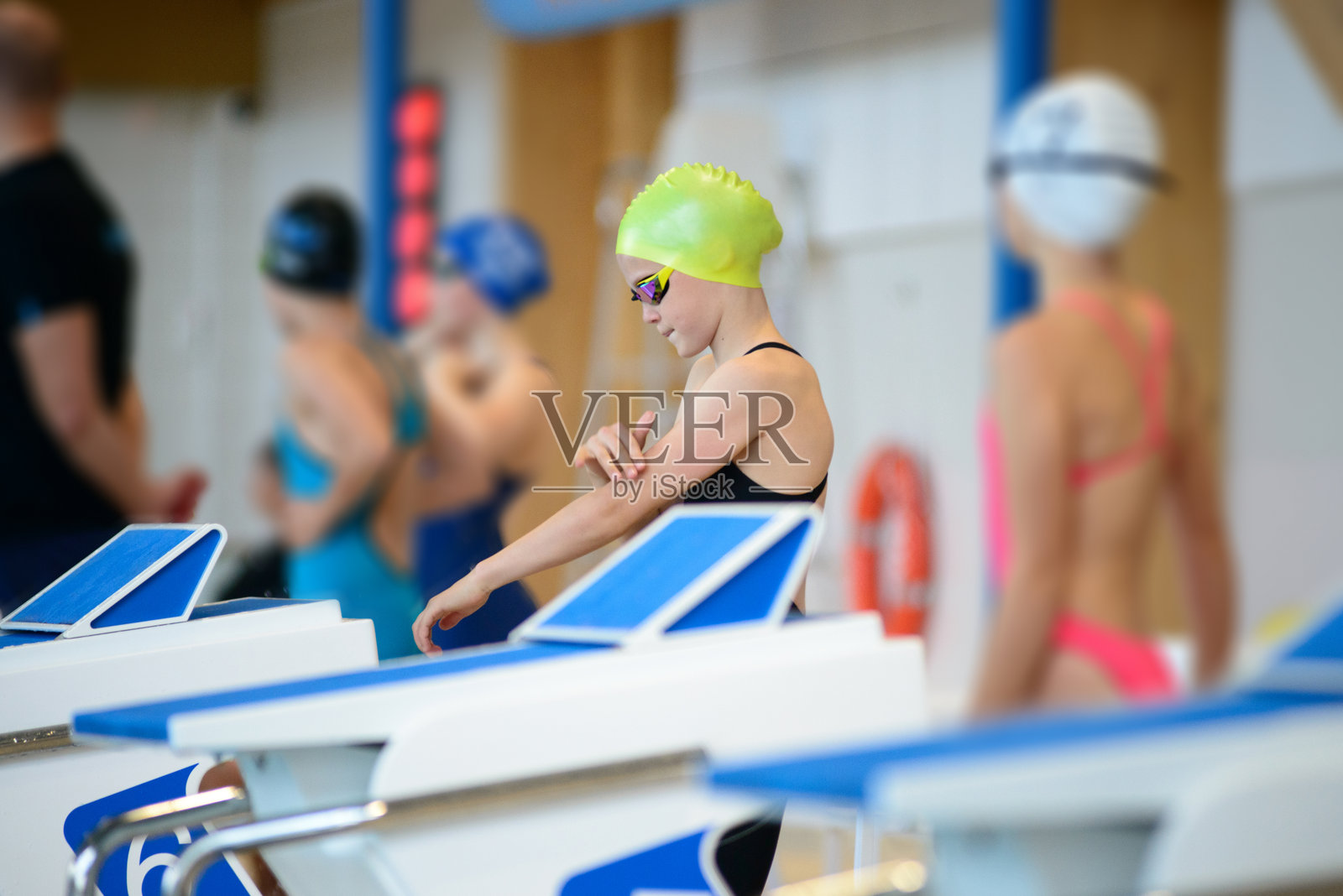 游泳女孩准备从泳池的起跳台起跳照片摄影图片