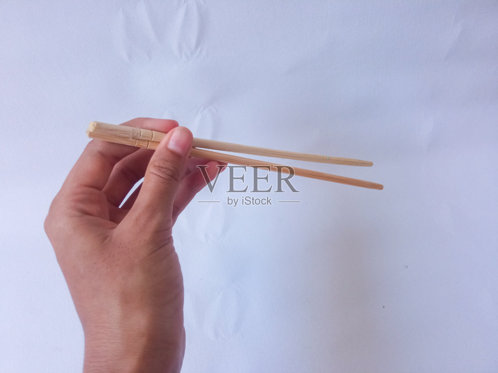 亚洲女性手持竹筷，背景为白色。照片摄影图片